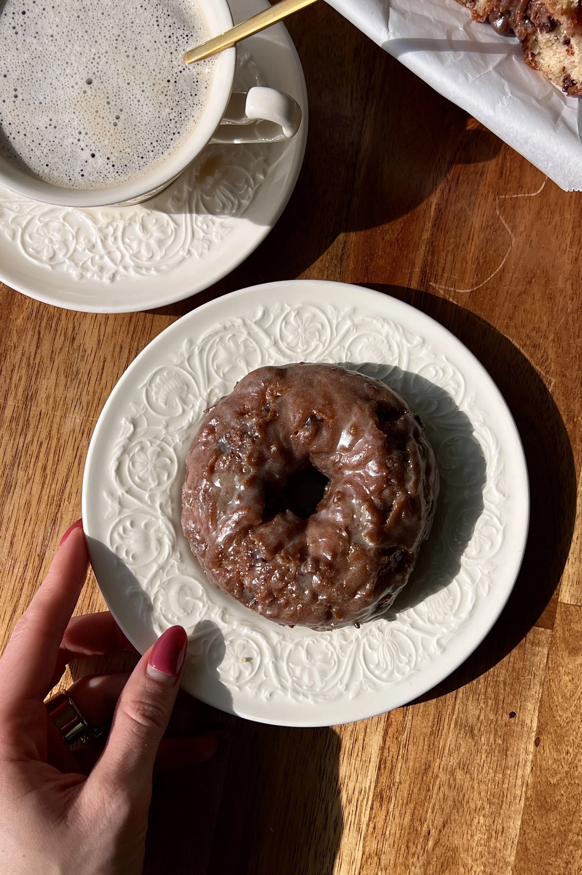 Soft and fluffy old-fashioned chocolate chip banana bread donuts fried until golden brown and coated in a silky salted brown butter honey glaze served warm with a hot cup of coffee.