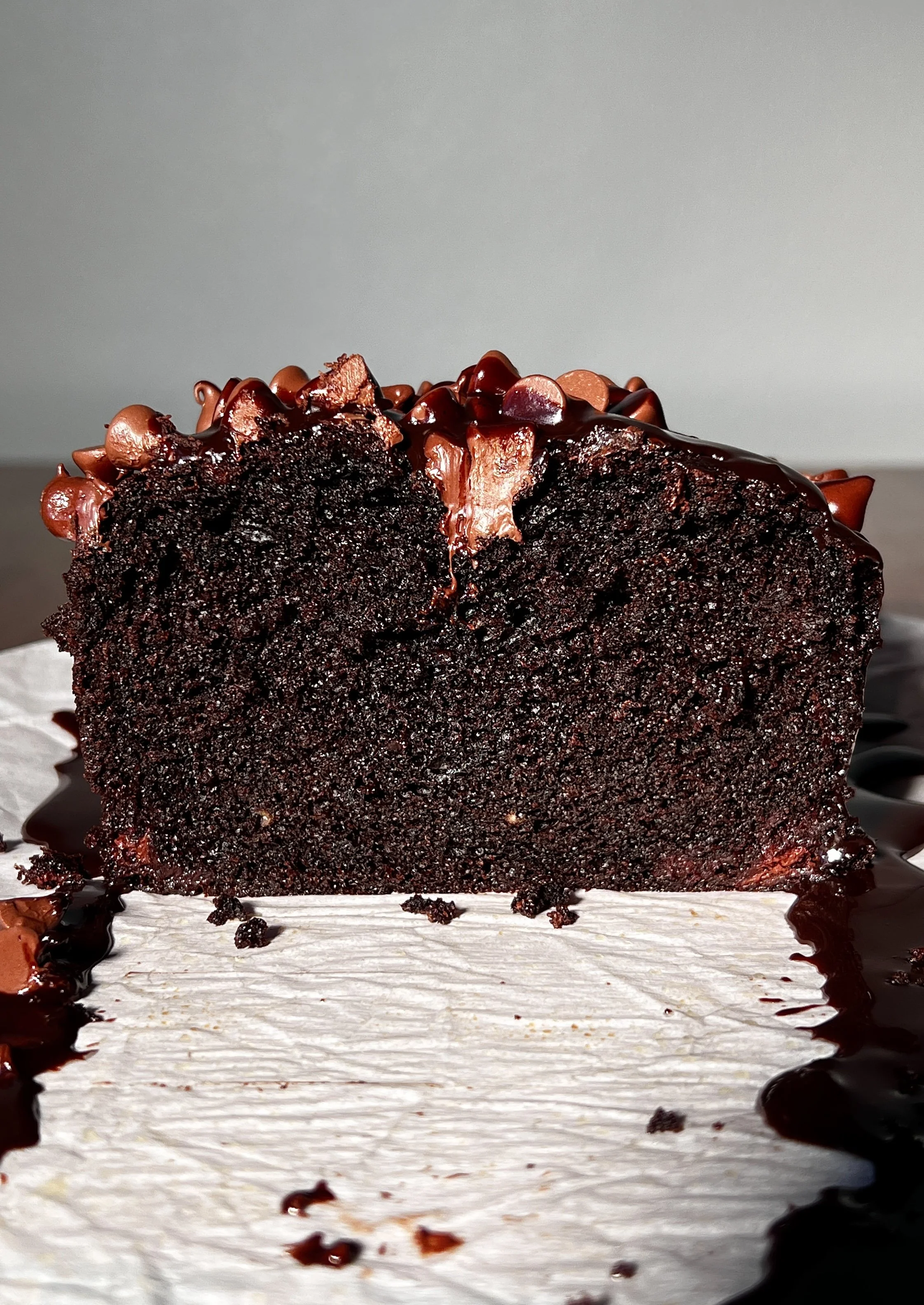 A warm and fudgy brown butter hot fudge brownie loaf with crisp edges, a gooey chocolate center, melty hot fudge sauce, vanilla ice cream, and flaky sea salt on top.