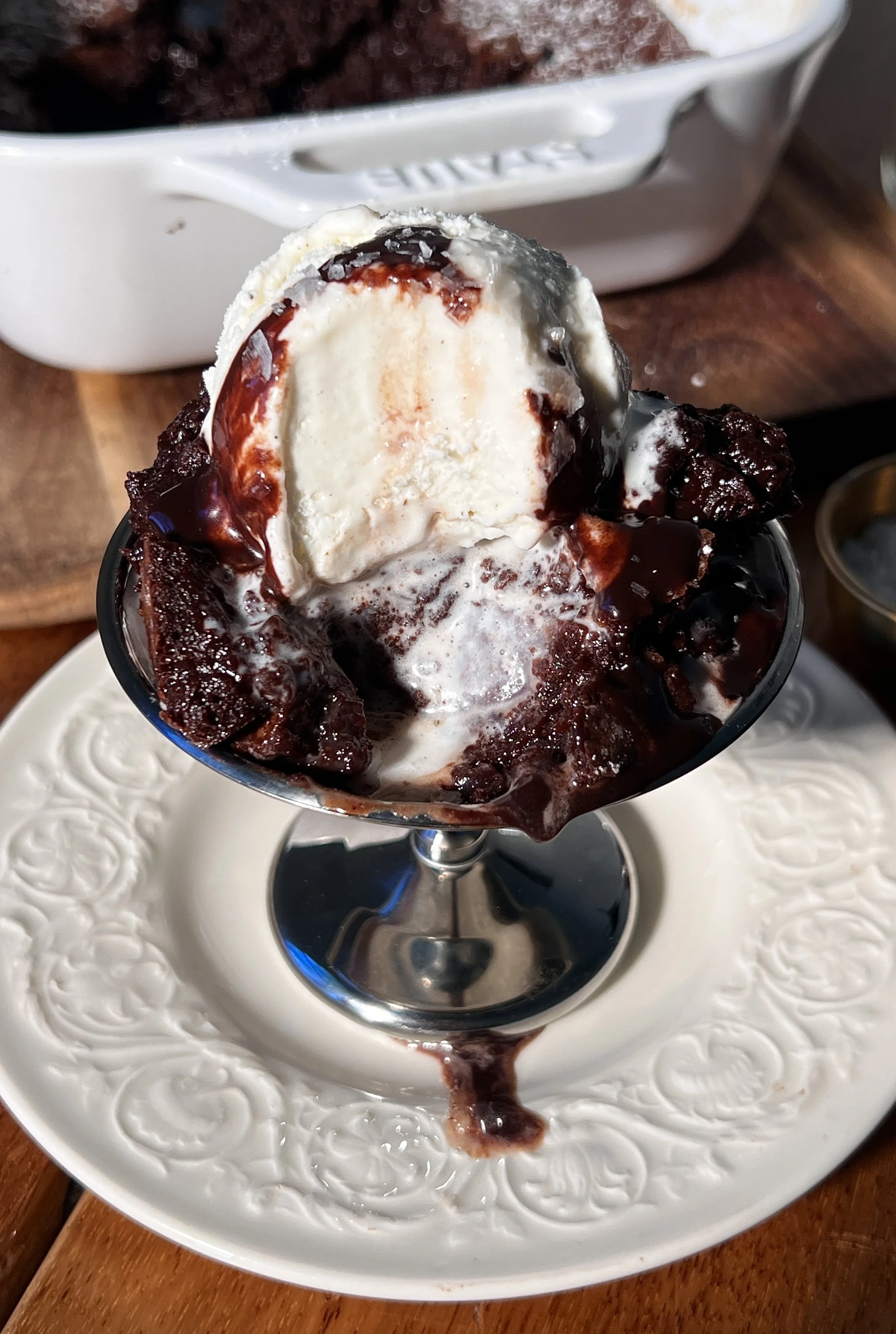 Warm deep dish brown butter molten lava cake with a gooey chocolate center, topped with vanilla ice cream and hot fudge.