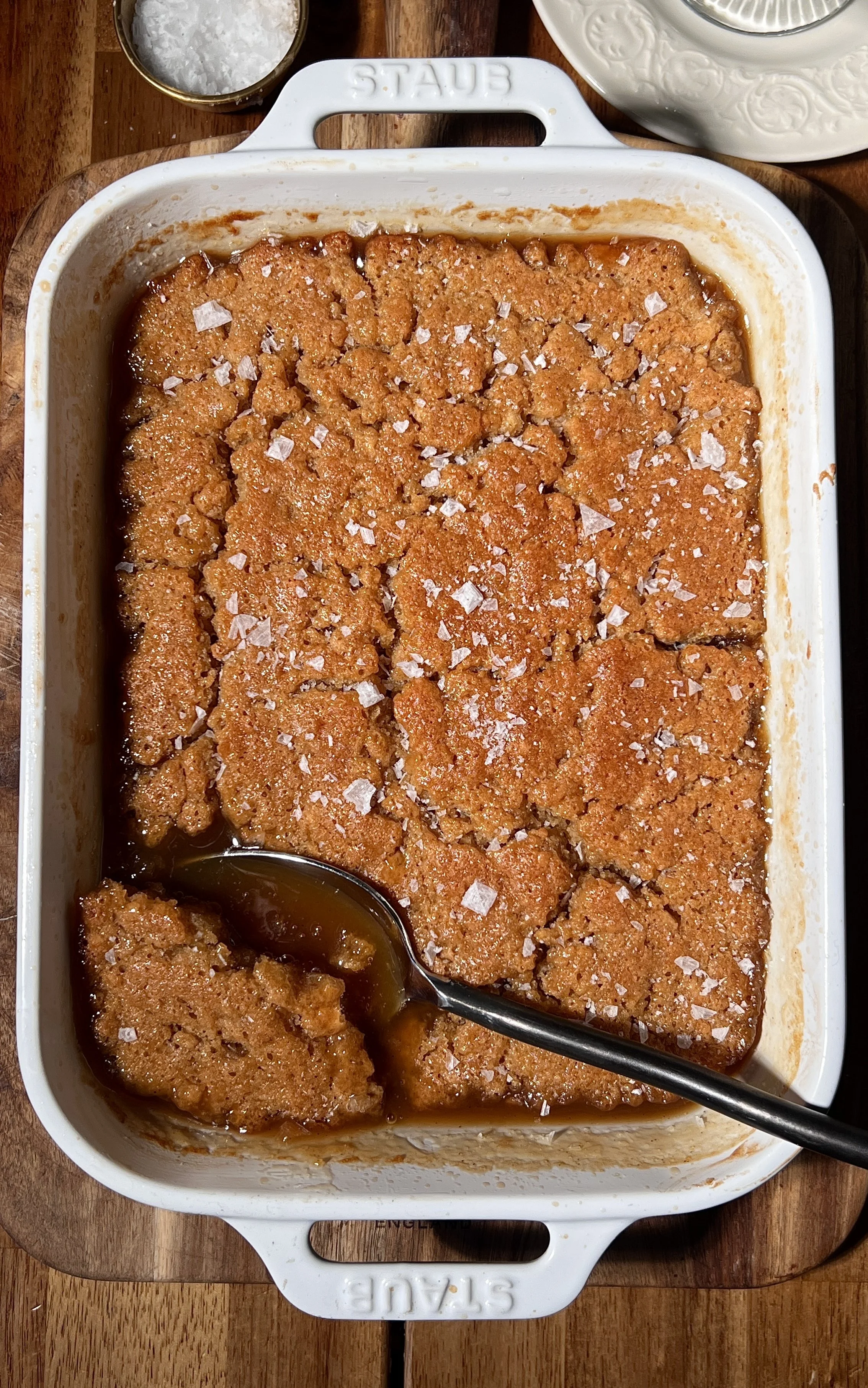 Salted maple pudding cake baked until golden with a crisp top and gooey maple sauce underneath, finished with flaky sea salt and served warm with a scoop of vanilla ice cream.