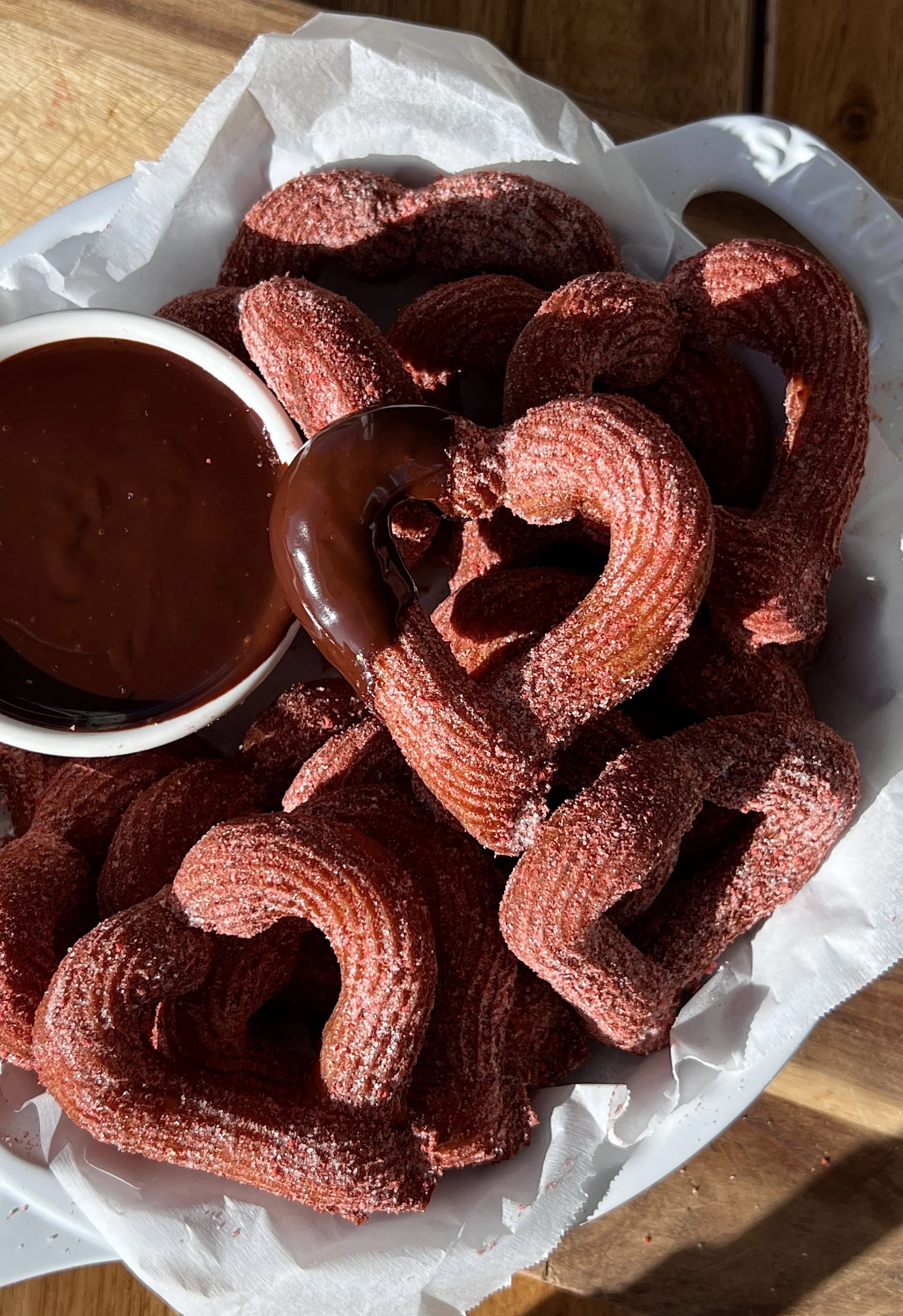 Warm heart churros for Valentine’s Day served with a rich homemade chocolate dipping sauce.