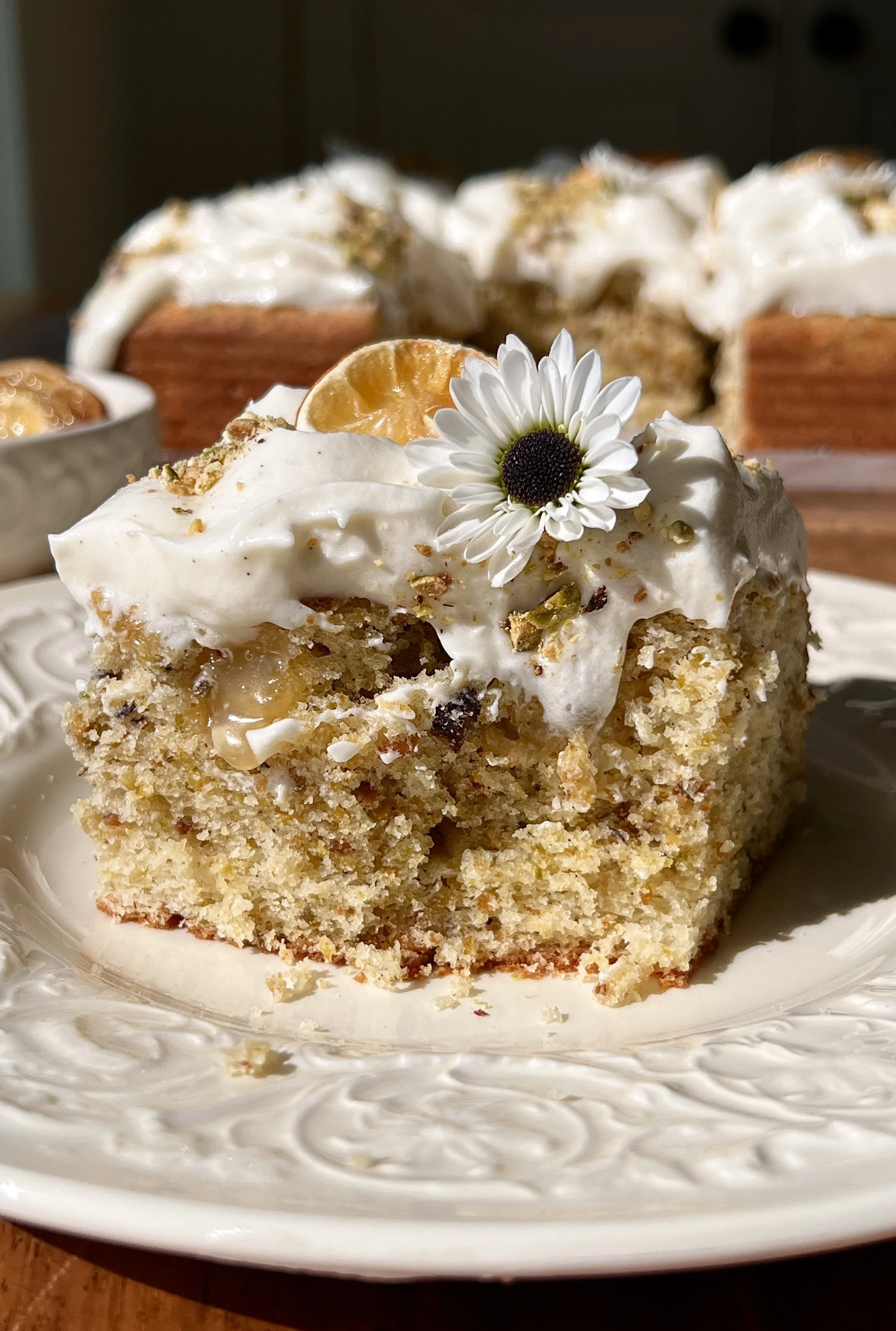 Soft and fluffy lemon pistachio cake filled with tart lemon curd and finished with smooth cream cheese frosting and chopped pistachios.