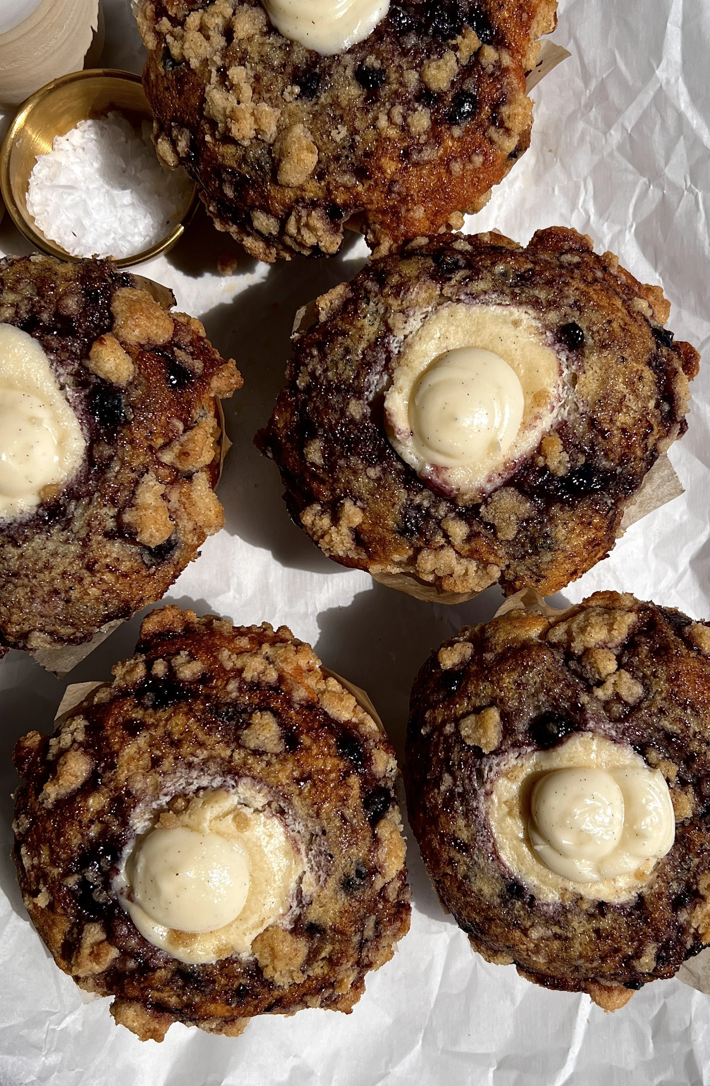 Close-up of blueberry cream cheese muffins with soft crumb, juicy blueberries, and buttery crumb topping.