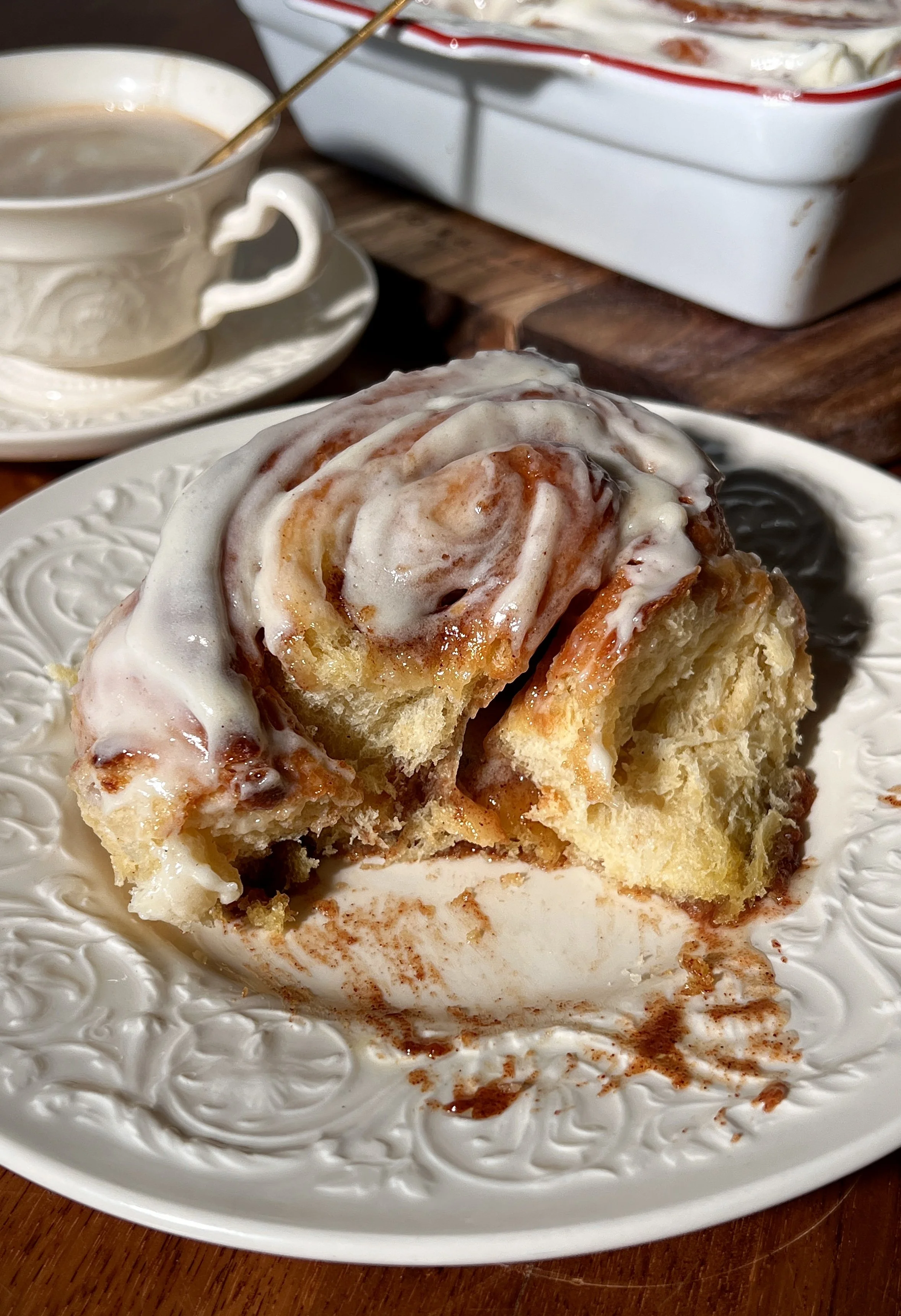 Soft, gooey eggnog cinnamon rolls in a baking dish, swirled with a golden brown sugar cinnamon filling and topped with melting eggnog cream cheese frosting.