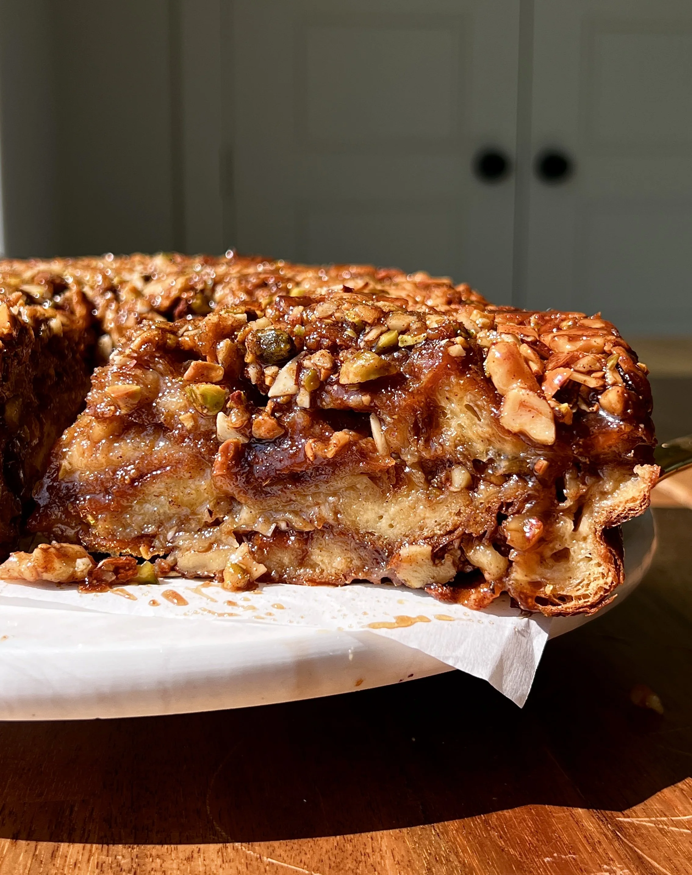 Close-up of baklava croissant bread pudding showing the buttery flaky croissants soaked in vanilla bean custard with a warm and gooey baklava filling throughout.