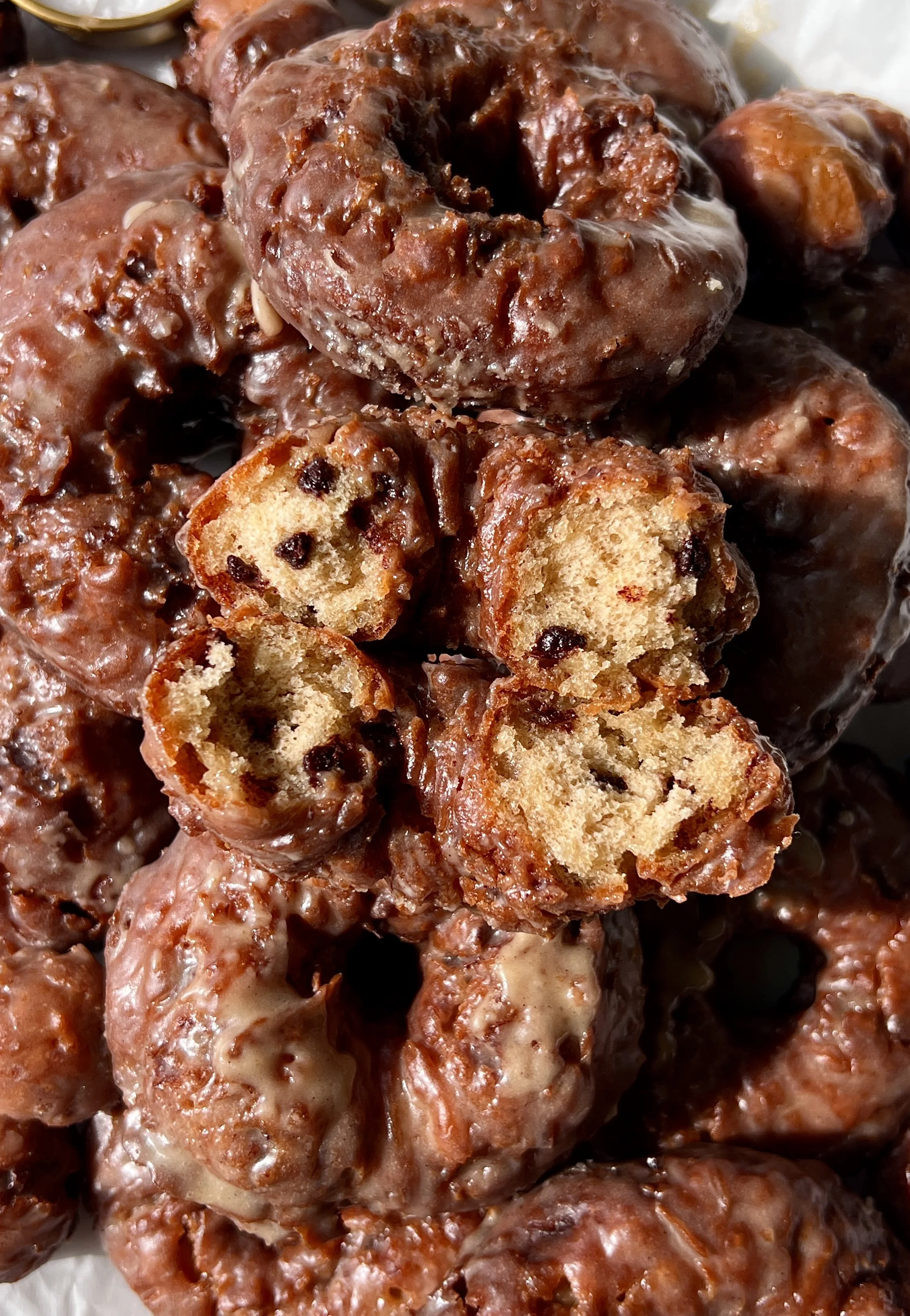 Close-up of a fluffy old-fashioned chocolate chip banana bread donut with a golden crisp exterior coated in a silky salted brown butter honey glaze.