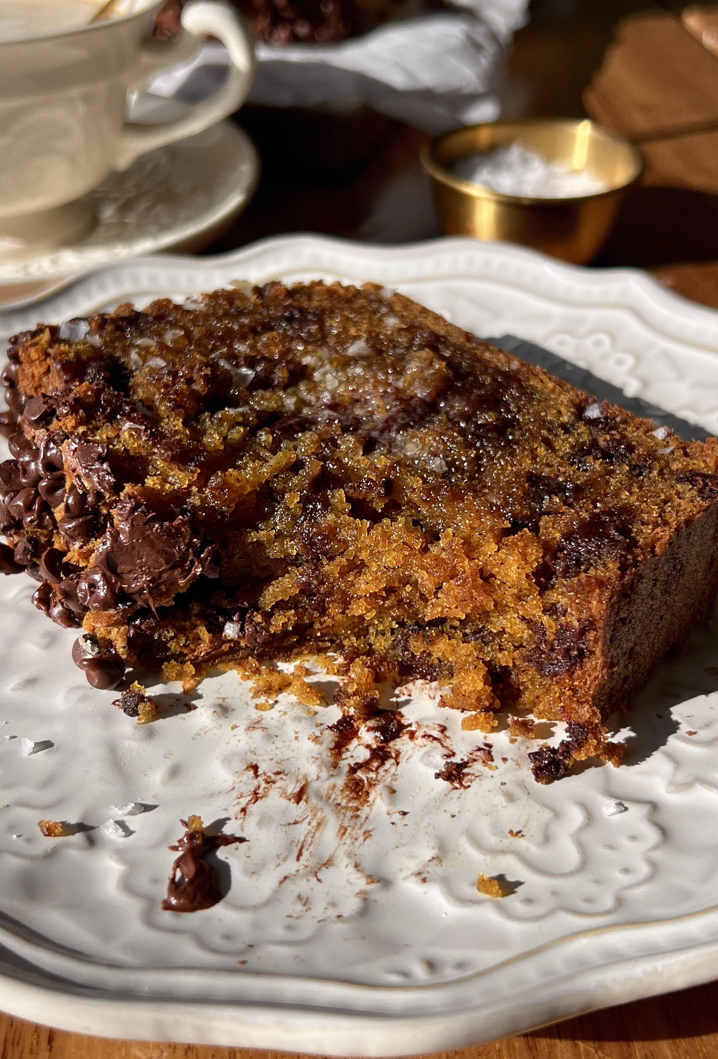 Close-up of a slice of brown butter chocolate chip pumpkin bread showing the soft tender crumb with melty chocolate chips throughout and a perfectly golden and slightly crisp exterior.