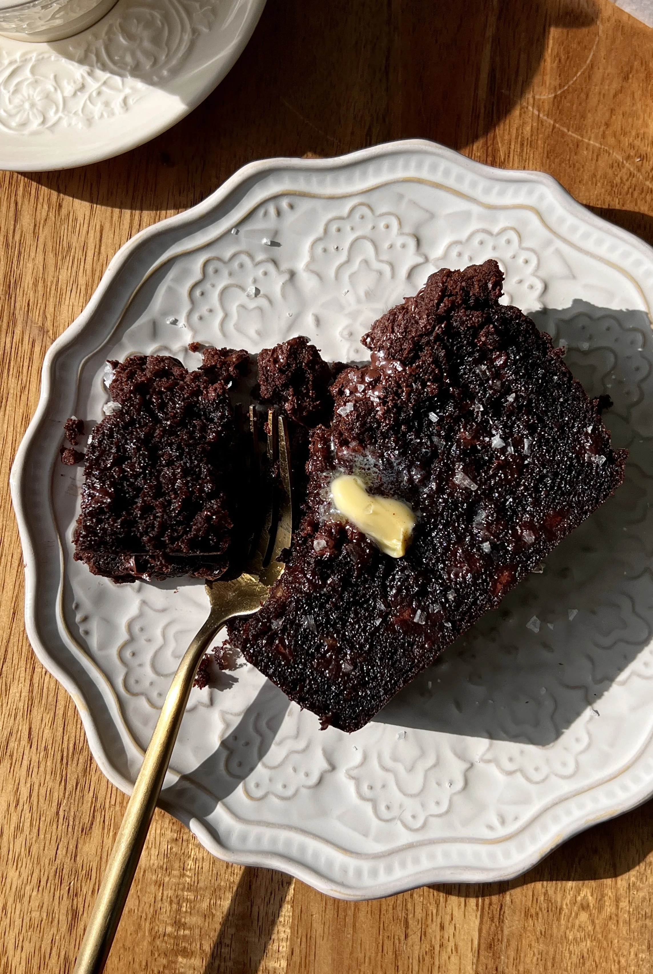 Soft and fluffy double chocolate crumb banana bread with brown butter, melty chocolate chips throughout, and a chocolate chip chocolate crumb topping served warm with a pat of butter and a sprinkle of flaky sea salt.