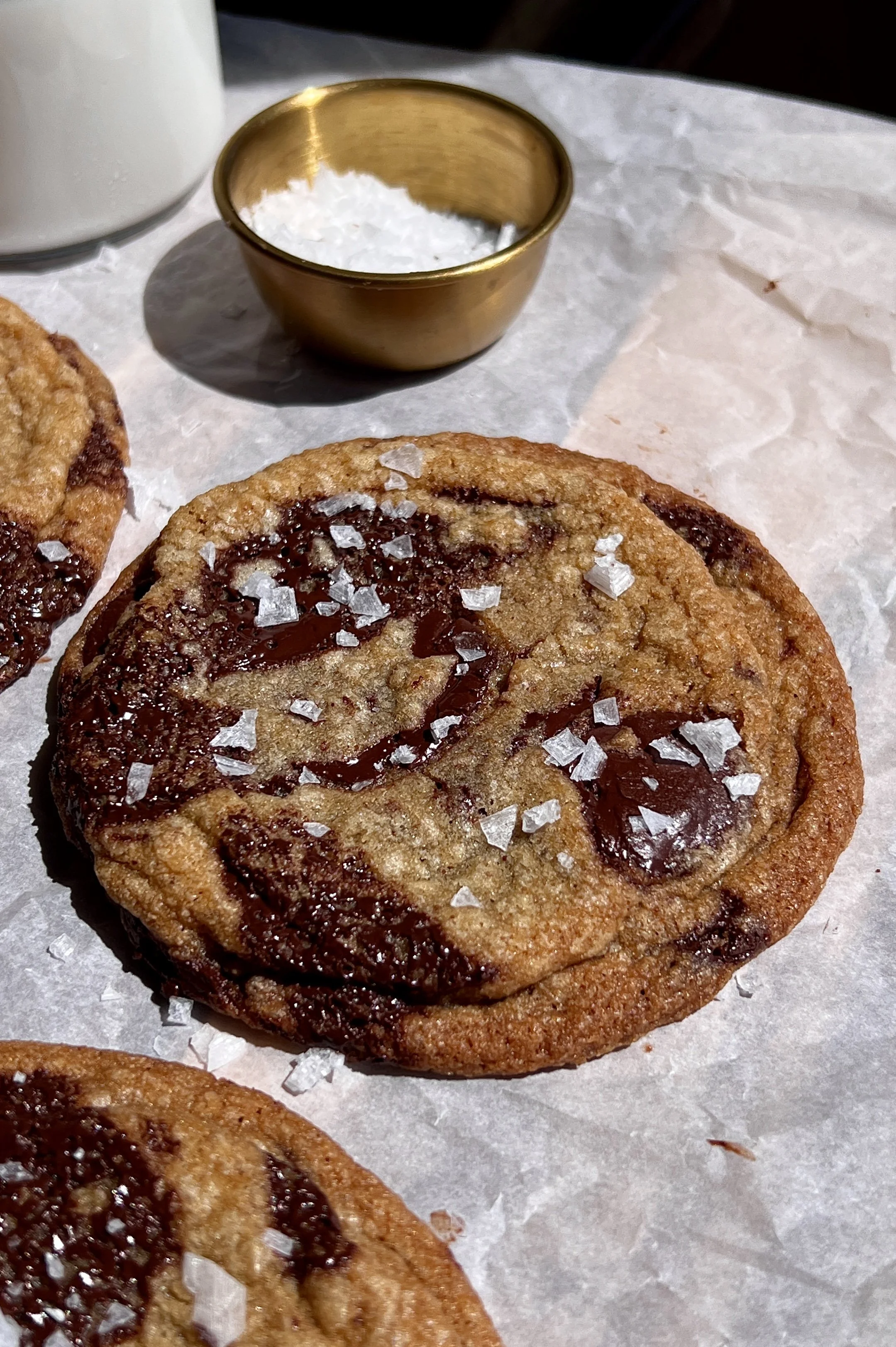 Crinkled brown butter chocolate chip cookies topped with flaky sea salt and served warm.