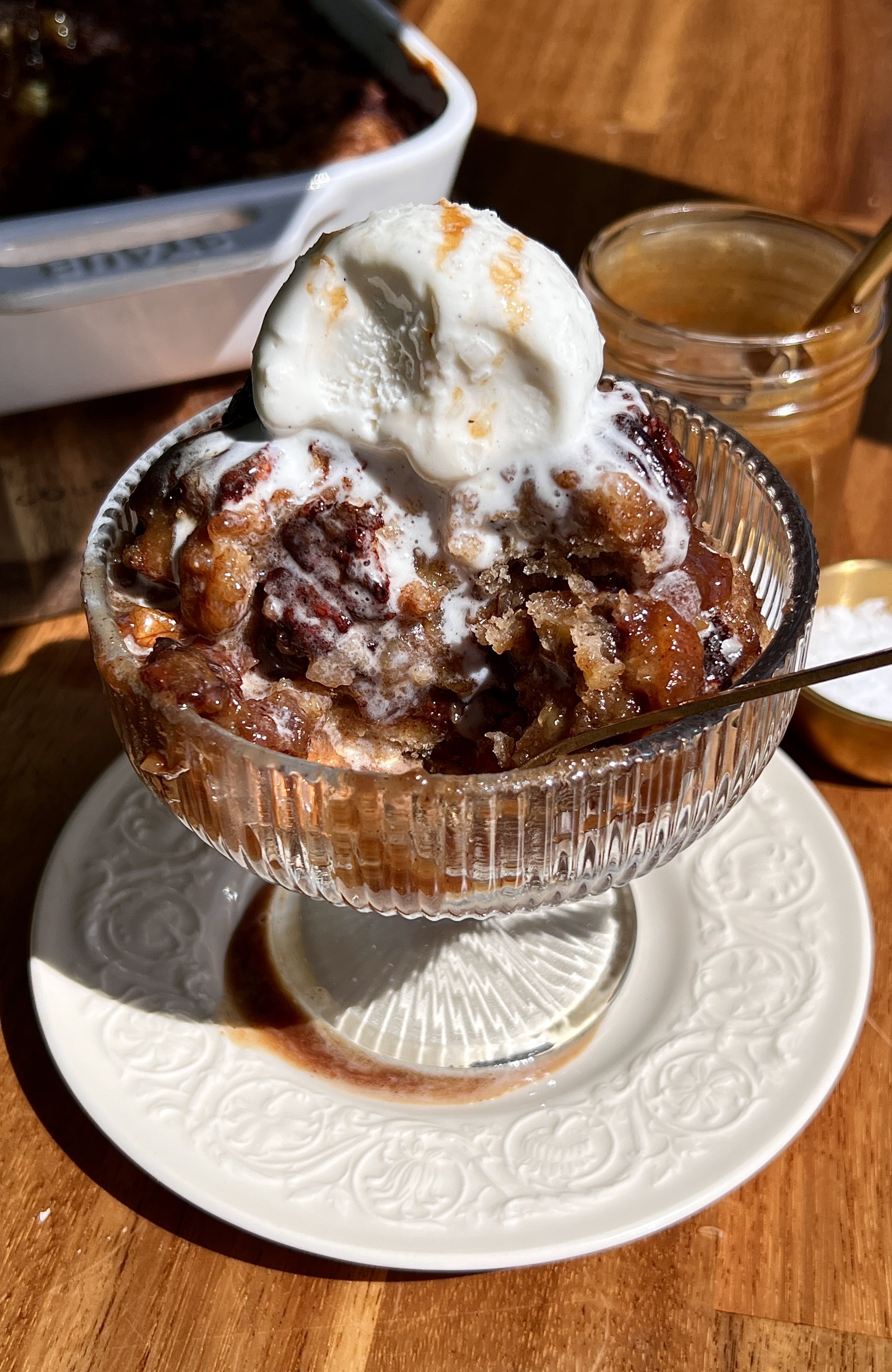 Warm self-saucing banana pudding cake served with vanilla ice cream, toasted pecans, and flaky sea salt.