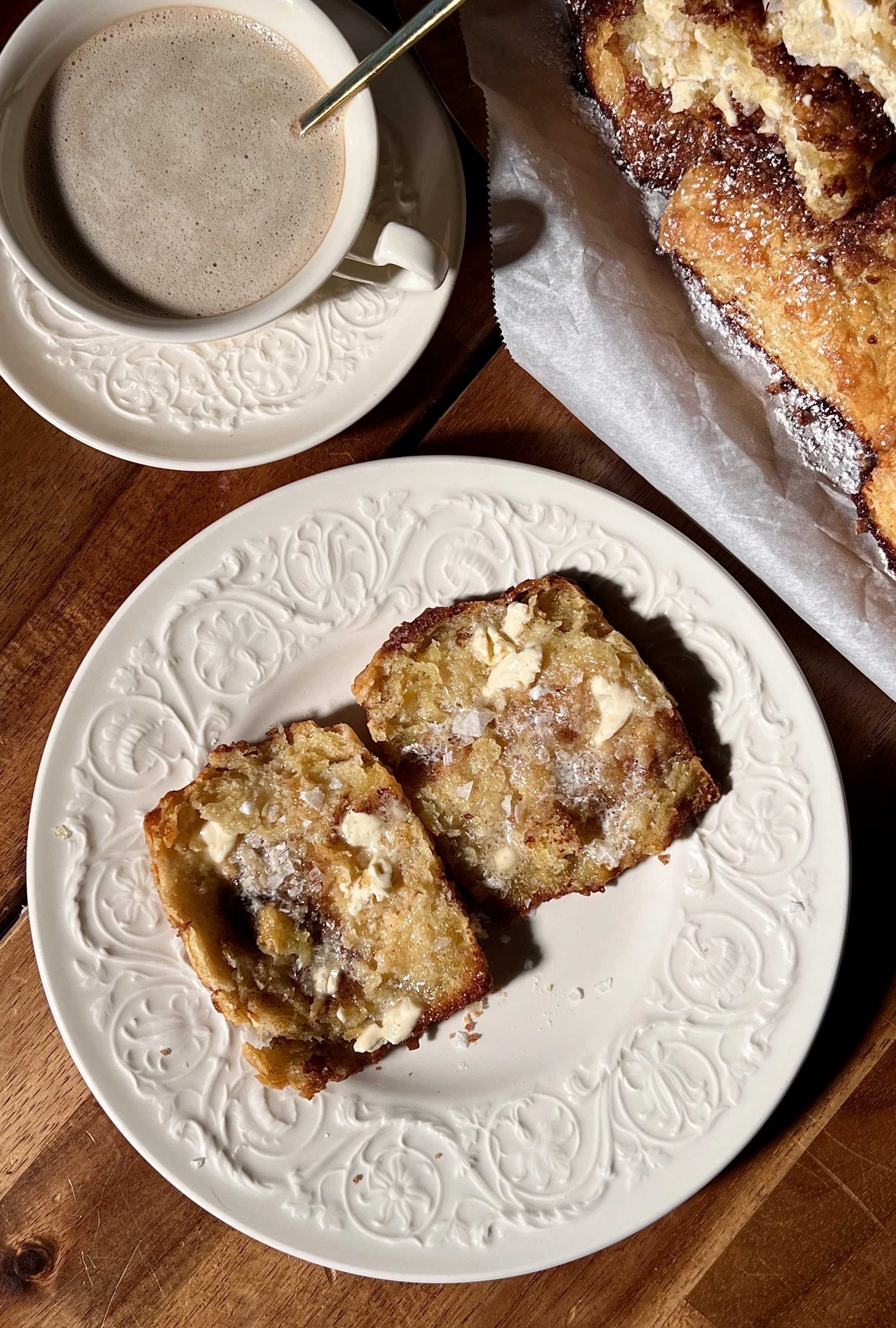 Warm French toast biscuits served with whipped salted maple butter and a cup of coffee.