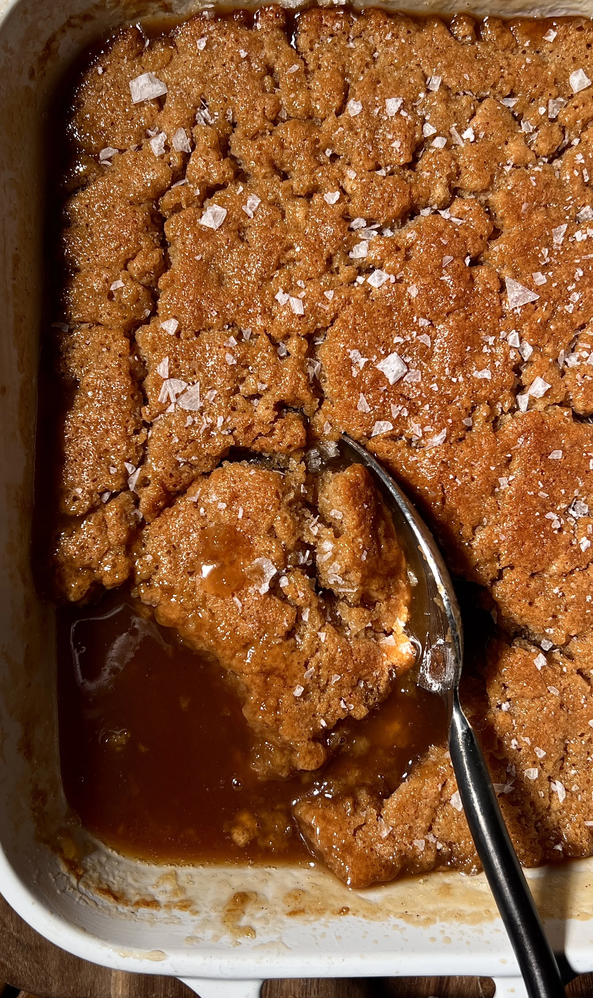 Salted maple pudding cake baked until golden with a crisp top and gooey maple sauce underneath, finished with flaky sea salt and served warm with a scoop of vanilla ice cream.