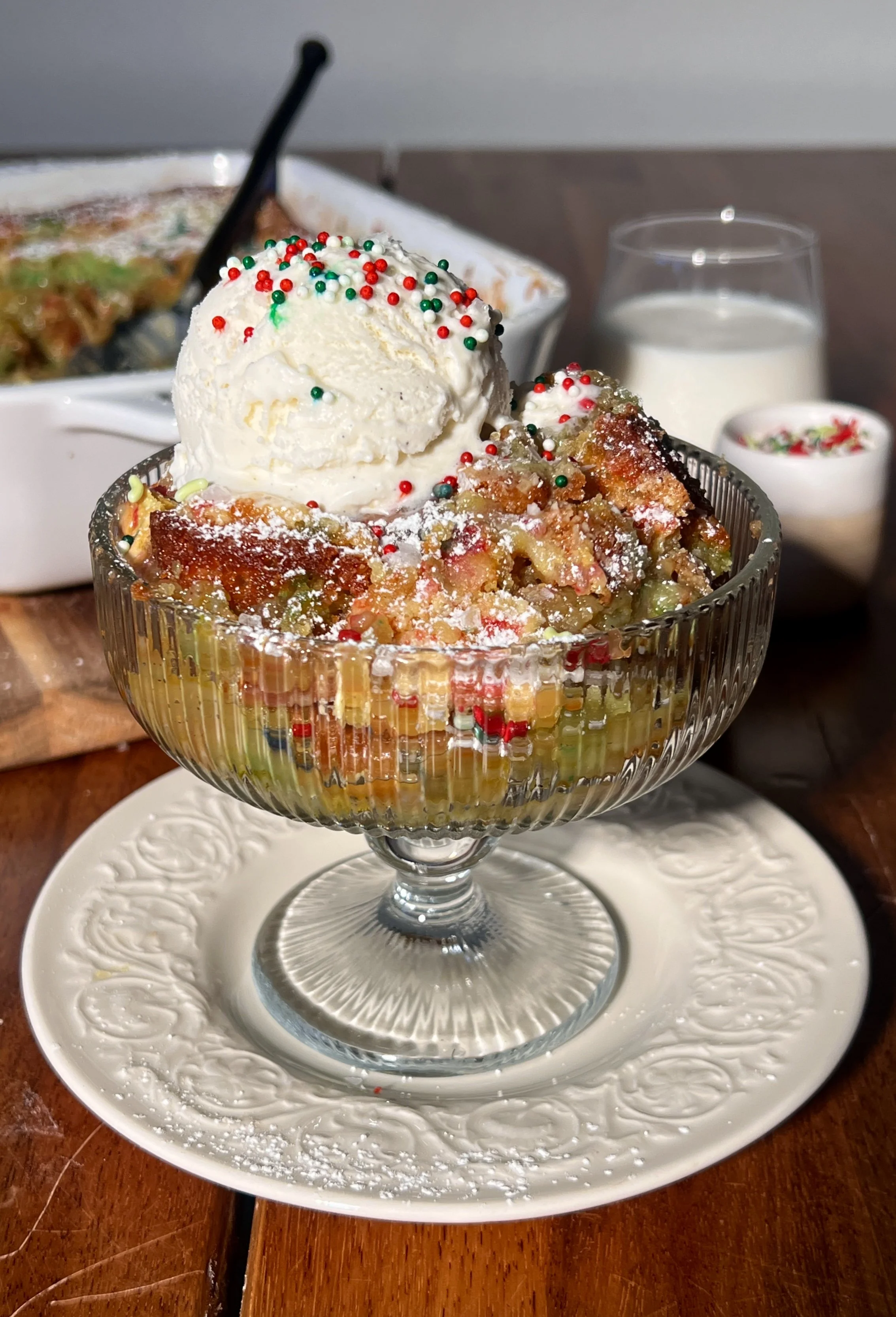 Warm slice of sugar cookie gooey butter cake with a soft sugar cookie base, a gooey cream cheese topping, a crackly golden surface, and a scoop of vanilla ice cream melting beside it.