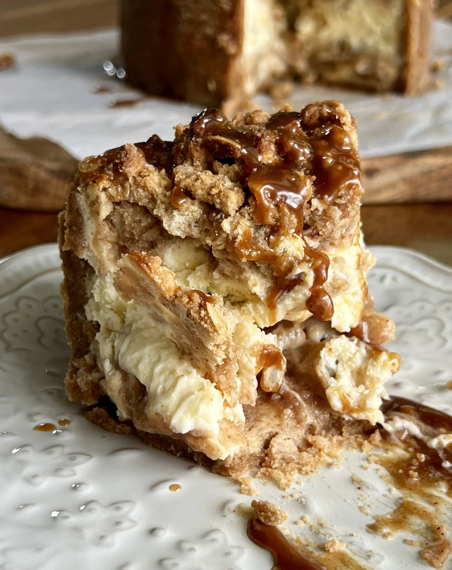 6-inch mini apple crumble cheesecake with a graham cracker crust, apple pie filling, and finished with a drizzle of salted caramel.