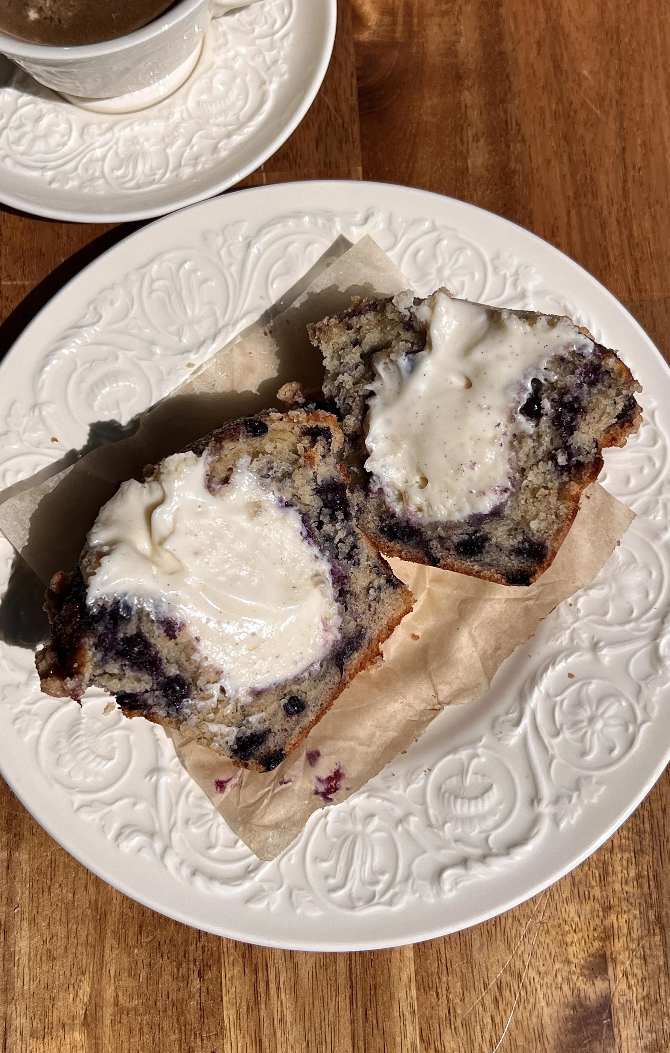 Blueberry muffin showing creamy cream cheese center surrounded by fluffy blueberry-filled crumb.