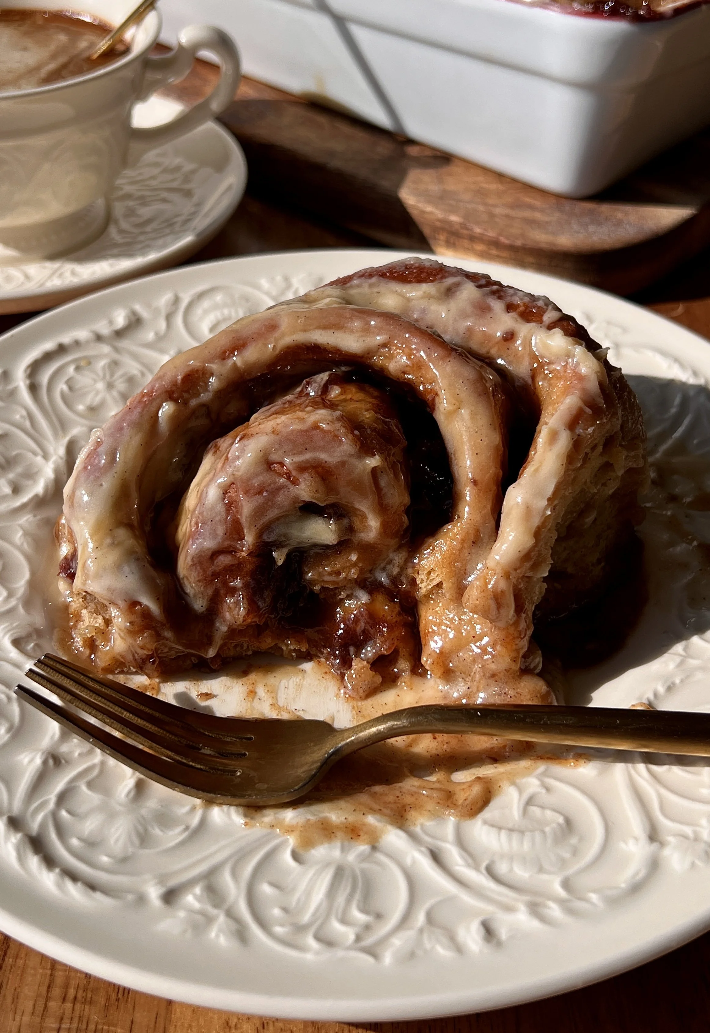 Soft and fluffy sticky toffee pudding cinnamon rolls with a pull-apart date dough and warm gooey cinnamon date filling finished with a rich maple toffee sauce and brown sugar cream cheese frosting served warm with a hot cup of coffee.