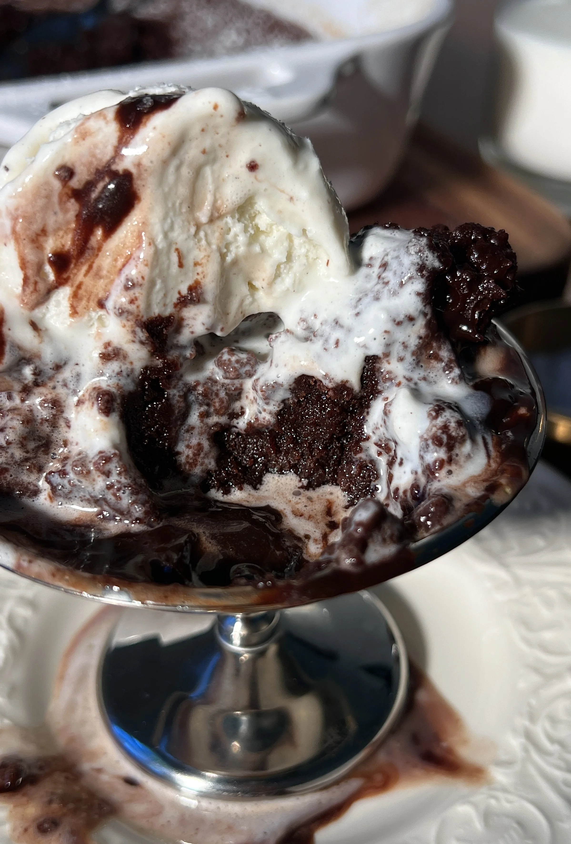 Warm deep dish brown butter molten lava cake with a gooey chocolate center, topped with vanilla ice cream and hot fudge.