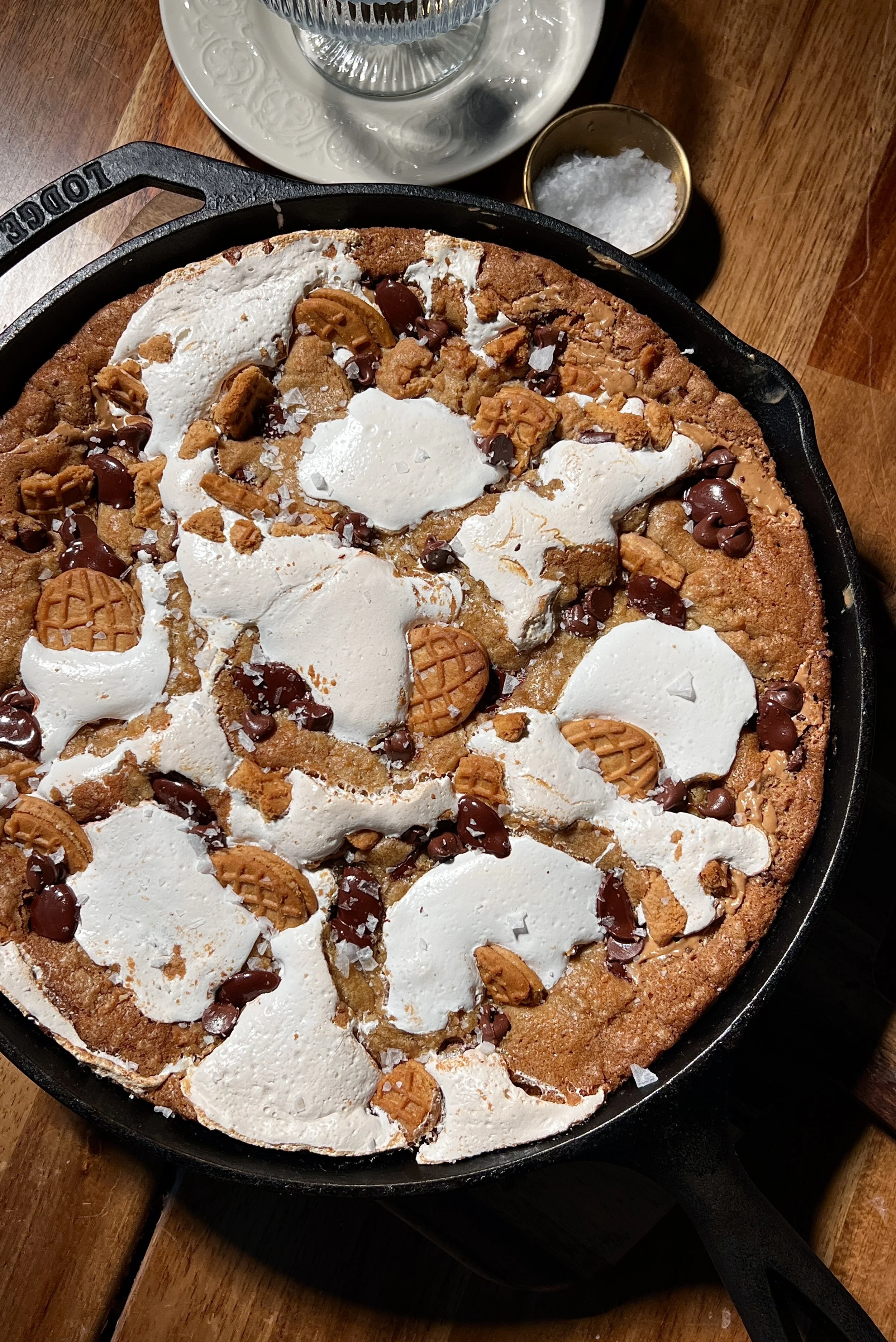 Fluffernutter chocolate chip cookie skillet with brown butter, featuring a gooey center, golden crisp edges, melty chocolate chips, peanut butter, marshmallow fluff, crushed Nutter Butter cookies, and vanilla ice cream on top.
