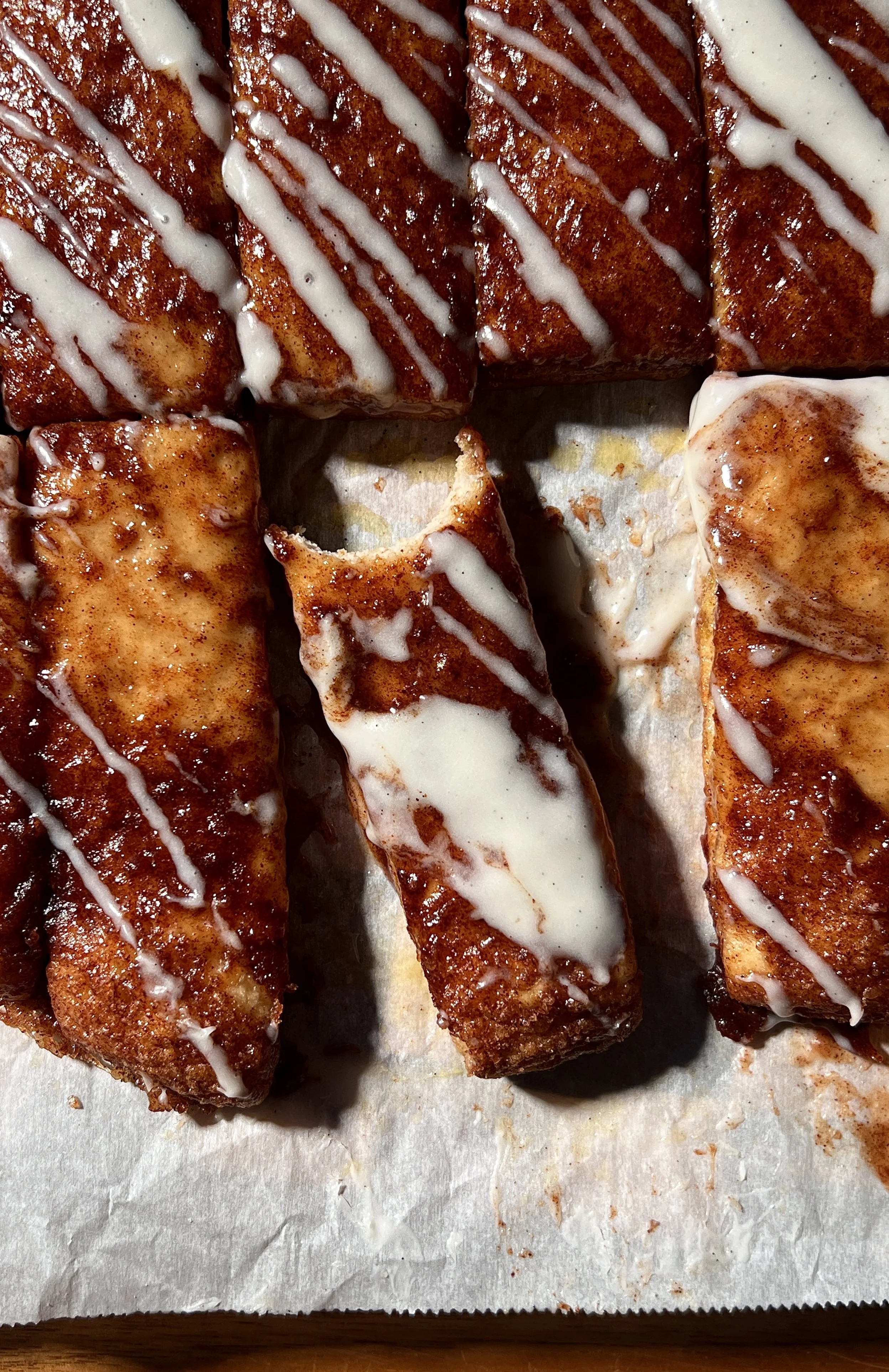 Soft and fluffy sourdough cinnasticks made with sourdough discard and Greek yogurt dough, topped with gooey cinnamon sugar and drizzled with a tangy cream cheese glaze, served warm.