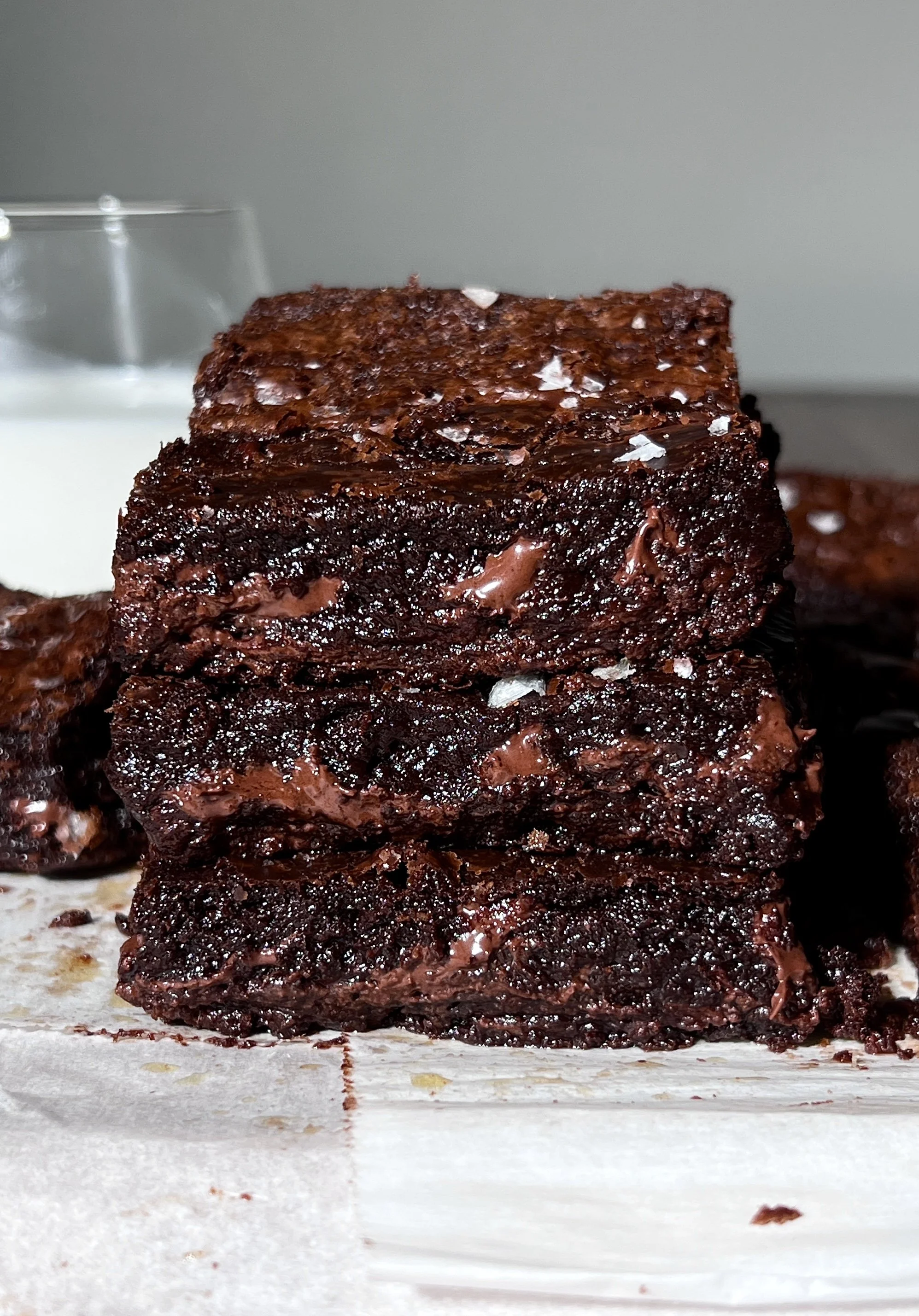 Stack of fudgy crinkle-top brown butter brownies with brown butter, espresso-enhanced chocolate, and flaky sea salt.