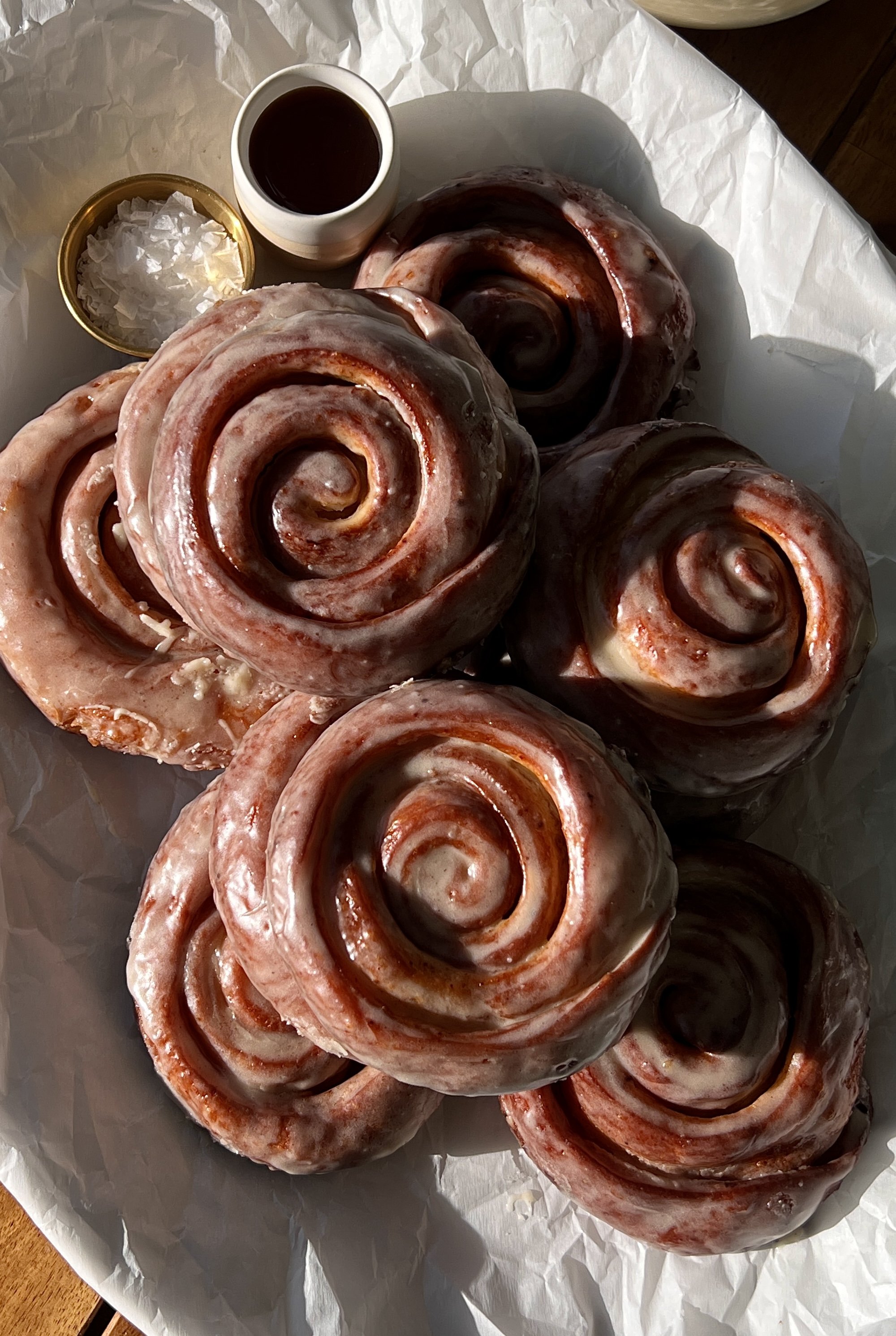 Homemade honey buns glazed with silky honey icing and served warm with a cup of coffee.