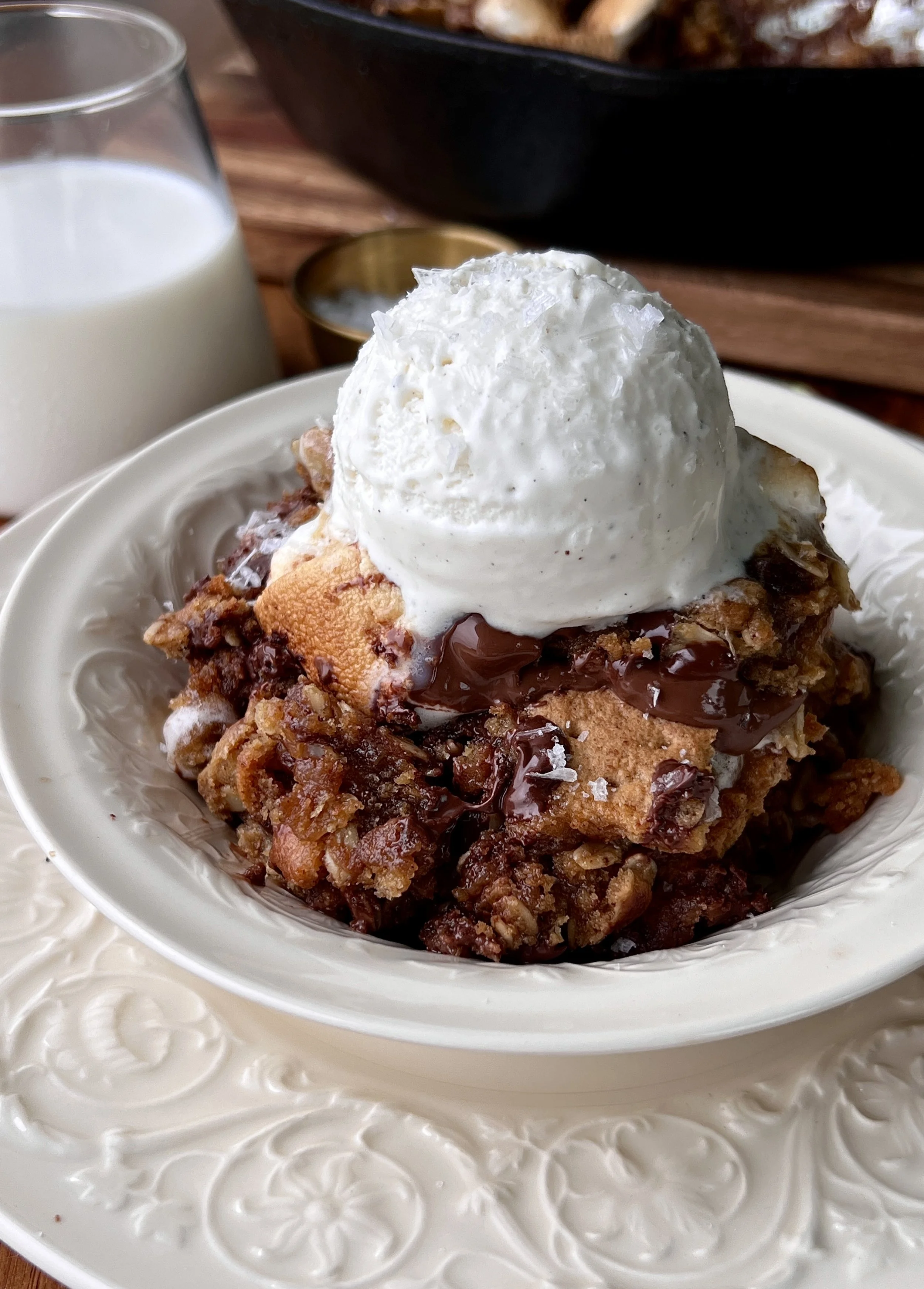 Soft and gooey peanut butter s'mores oatmeal cookie skillet made with brown butter, melty chocolate, toasted marshmallows, and crushed graham crackers served warm with a scoop of vanilla ice cream and flaky sea salt.