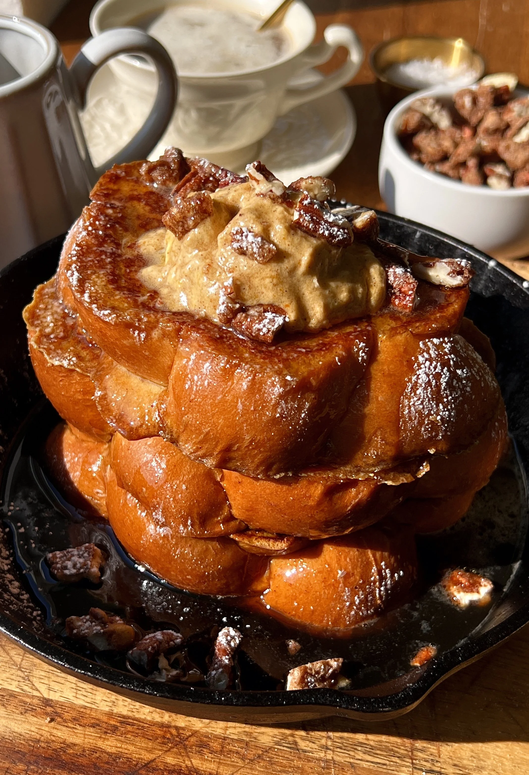 Pumpkin spice french toast with a golden exterior and soft custardy center served warm with a pat of butter, whipped pumpkin mascarpone, powdered sugar, and maple syrup.