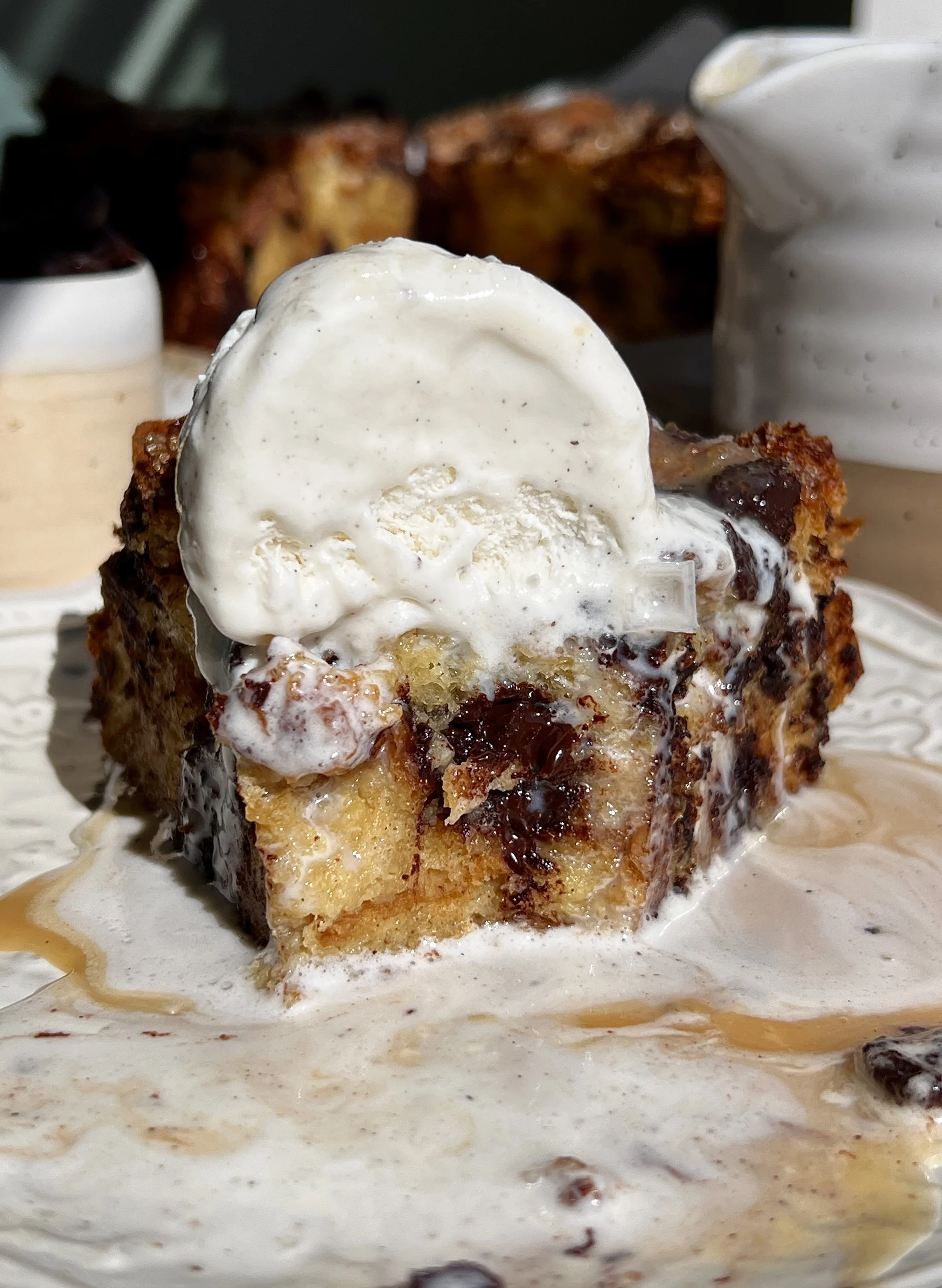 Close-up of chocolate chip bread pudding with soft custard-soaked brioche and melted chocolate chips.
