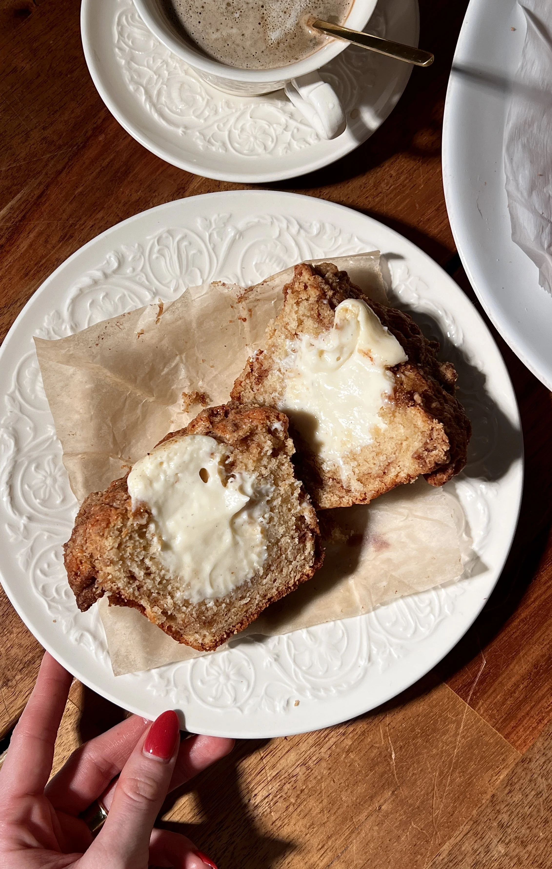 Brown butter cinnamon roll cream cheese muffins with a tender crumb, cinnamon swirl throughout, and a crumb topping, served warm with a cup of coffee.