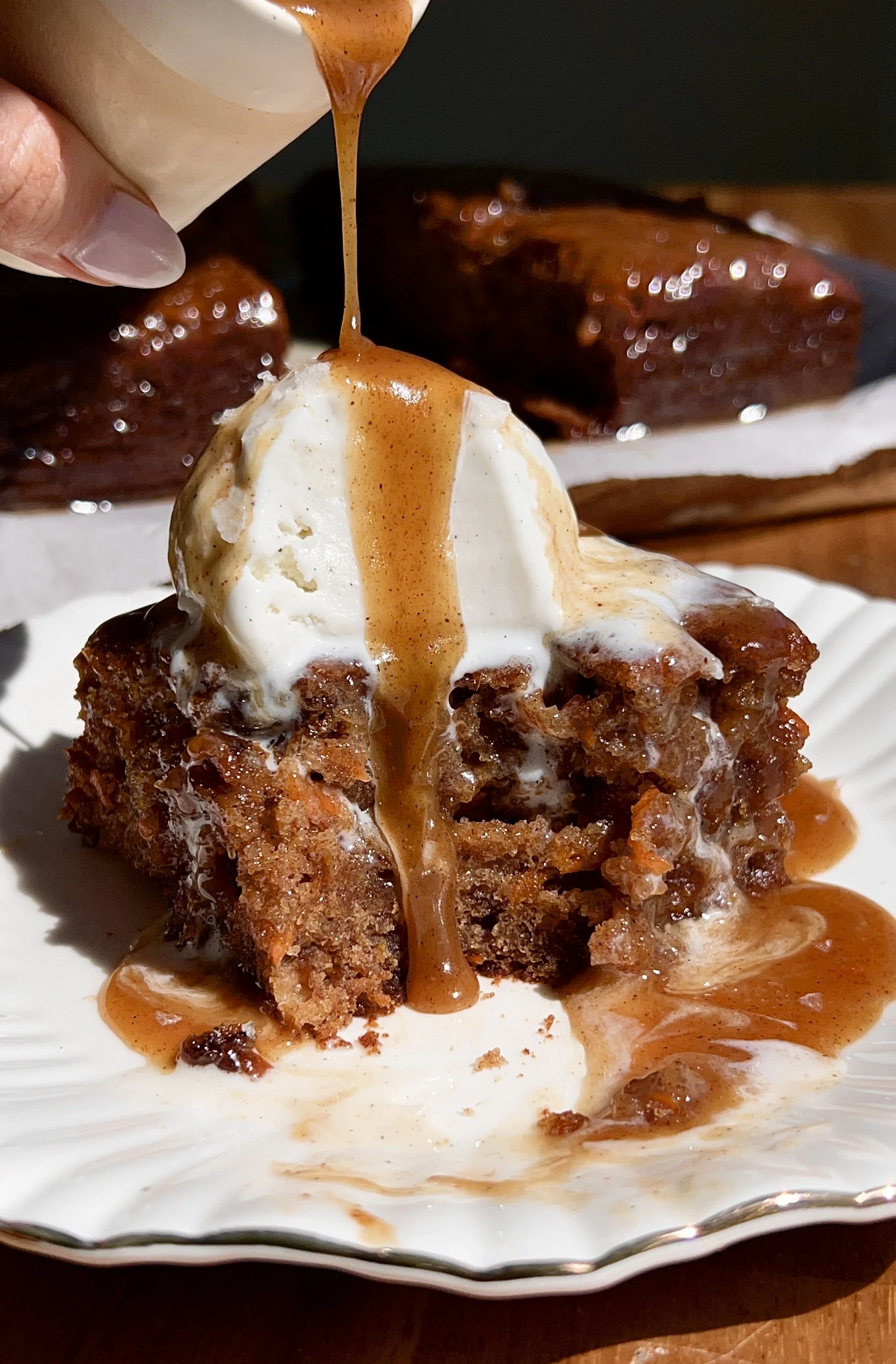 Warm carrot cake sticky toffee pudding served with spiced toffee sauce, vanilla ice cream, and flaky sea salt.