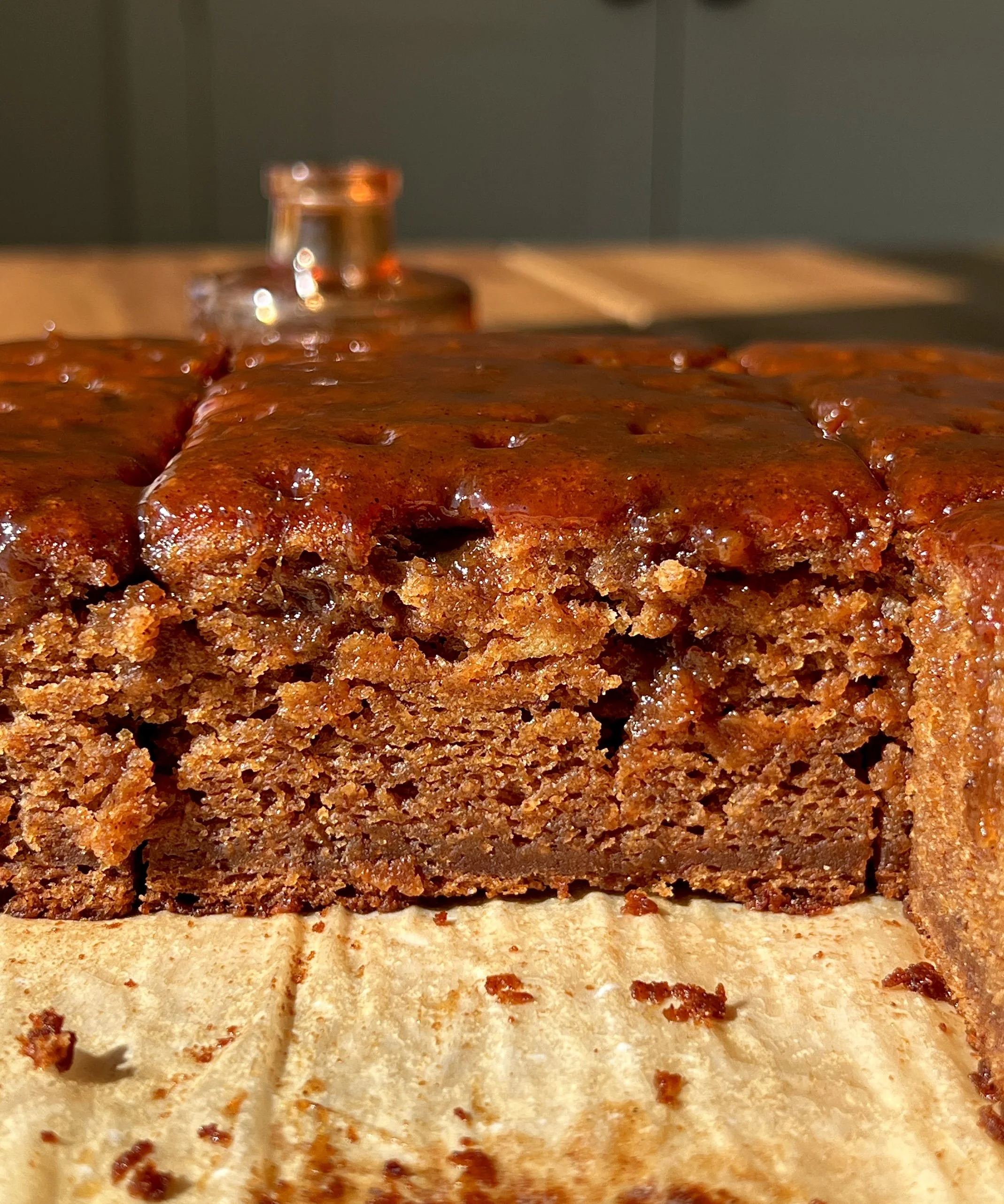 Slice of sweet potato sticky toffee pudding showing the soft tender beautifully spiced cake soaked with a silky sweet potato toffee sauce served warm with a scoop of vanilla ice cream and a sprinkle of flaky sea salt.