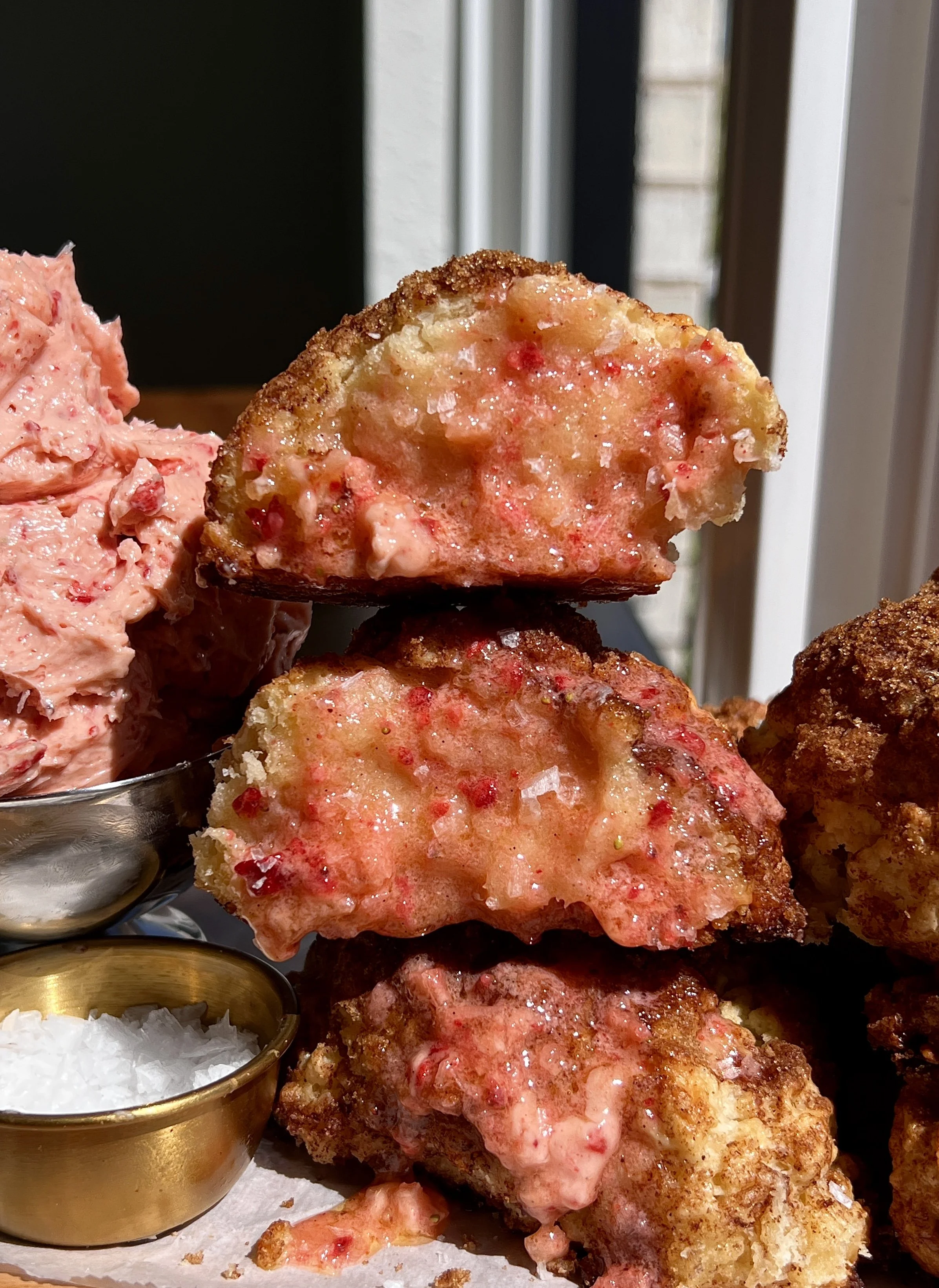 Stack of golden cinnamon crunch sourdough cathead biscuits served warm with whipped strawberry honey butter and a hot cup of coffee.