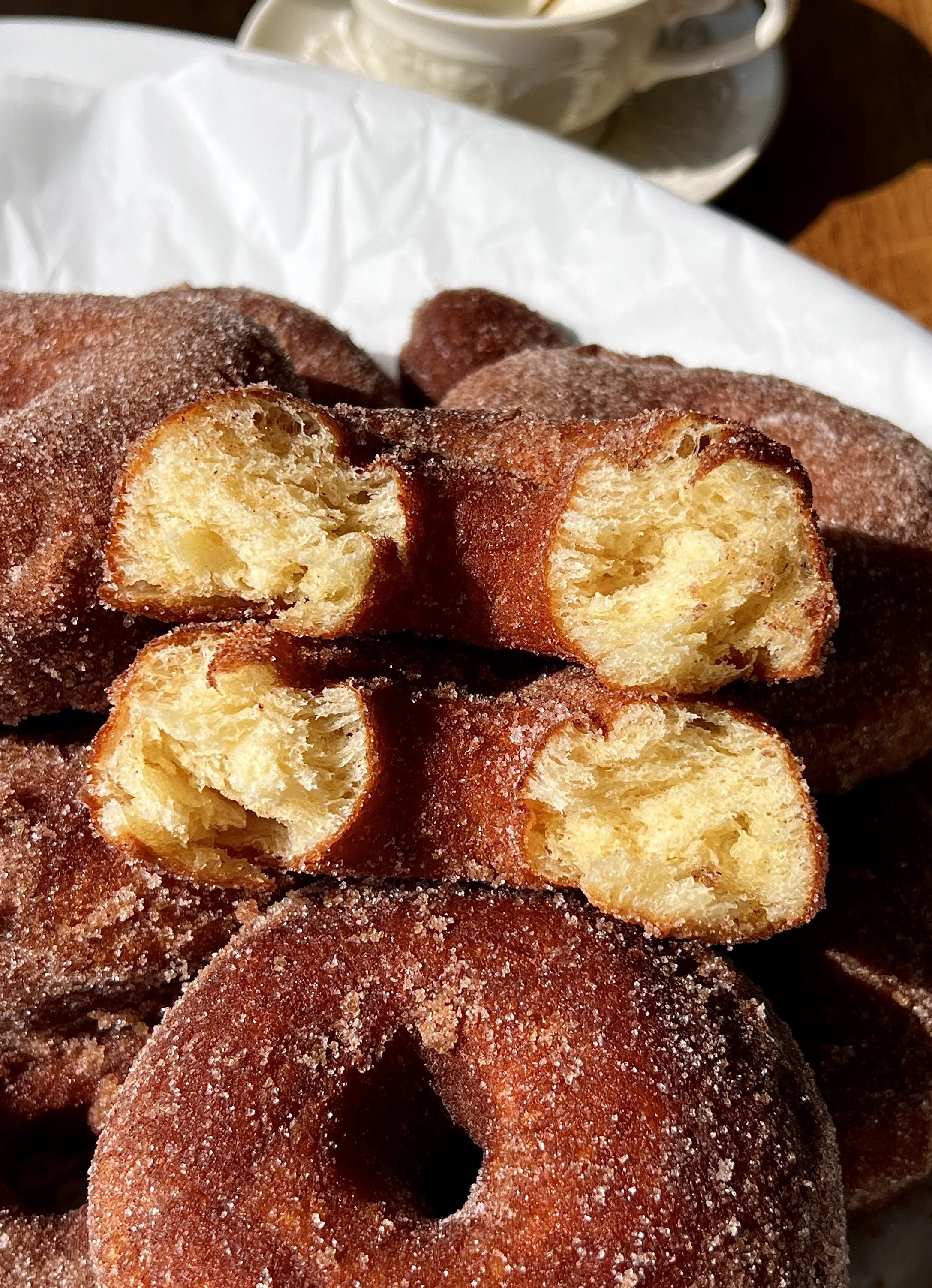 Close-up of a pillowy soft cinnamon sugar milk bread donut showing the beautifully golden exterior with just the right amount of chew and the incredibly soft and fluffy interior throughout.
