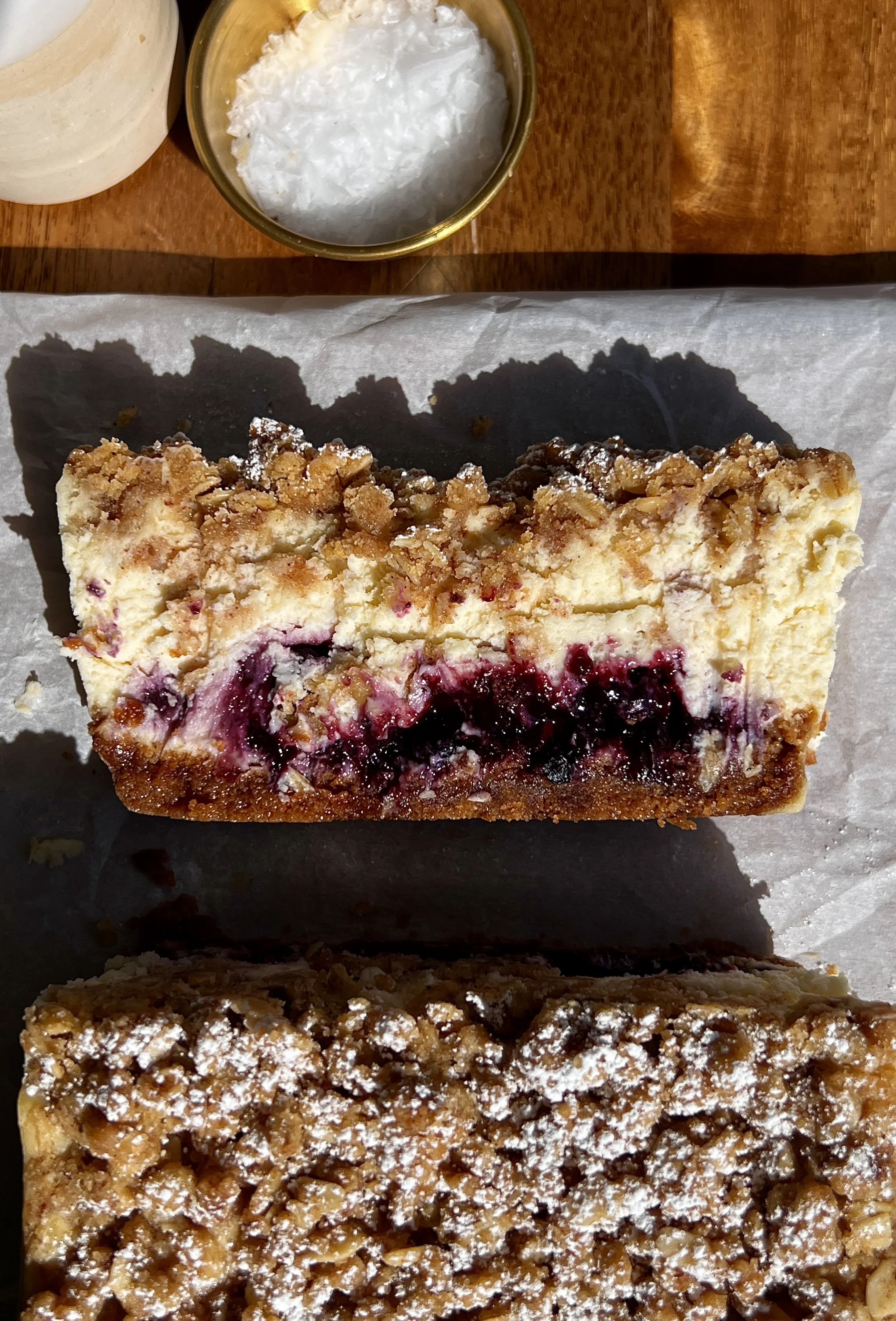 Blueberry crumble cheesecake bars with a Biscoff cookie crust, vanilla bean cheesecake filling, blueberry compote, and golden crumble topping.