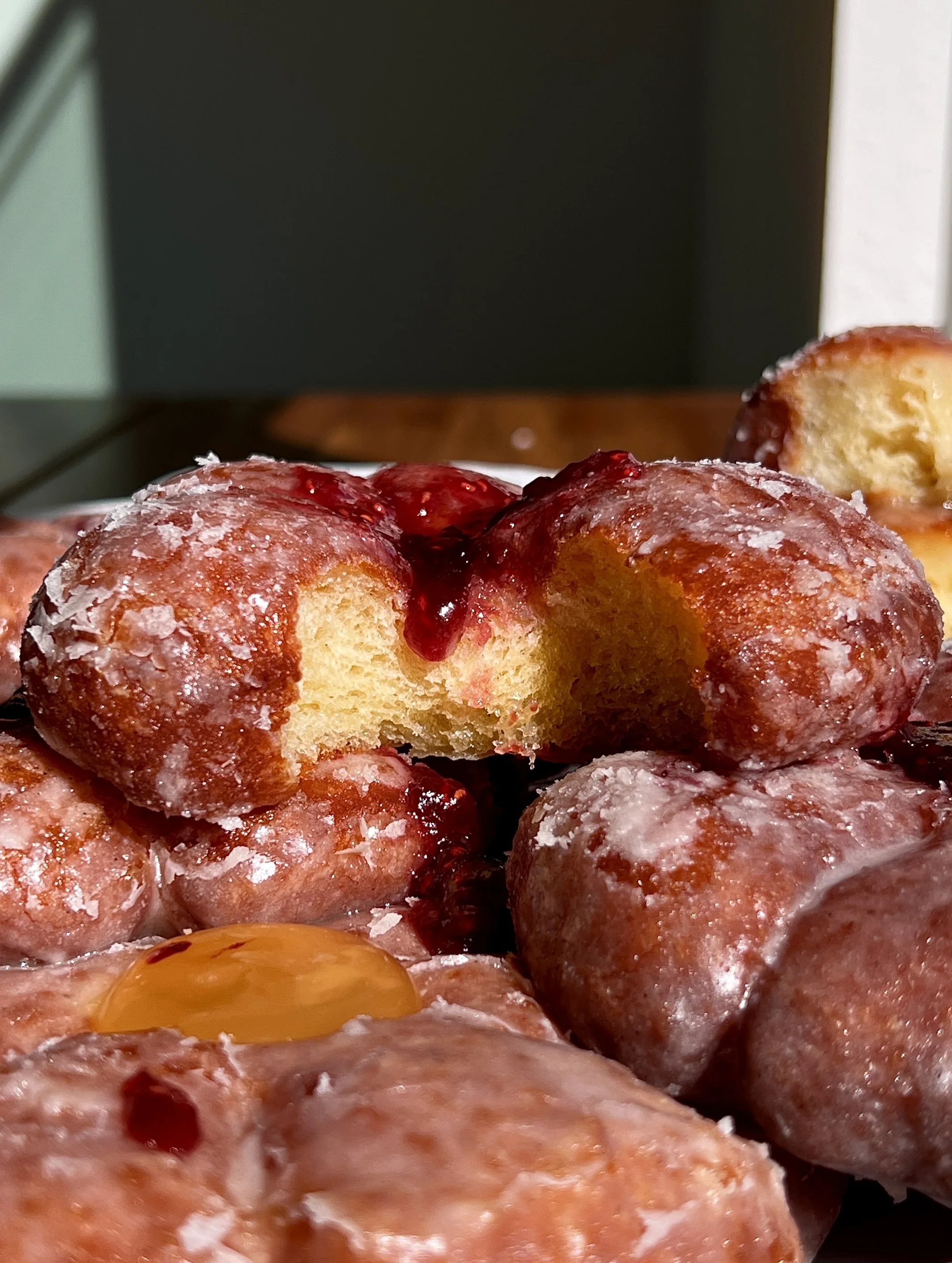 Flower donut filled with fruit preserves or lemon curd with glossy vanilla glaze.