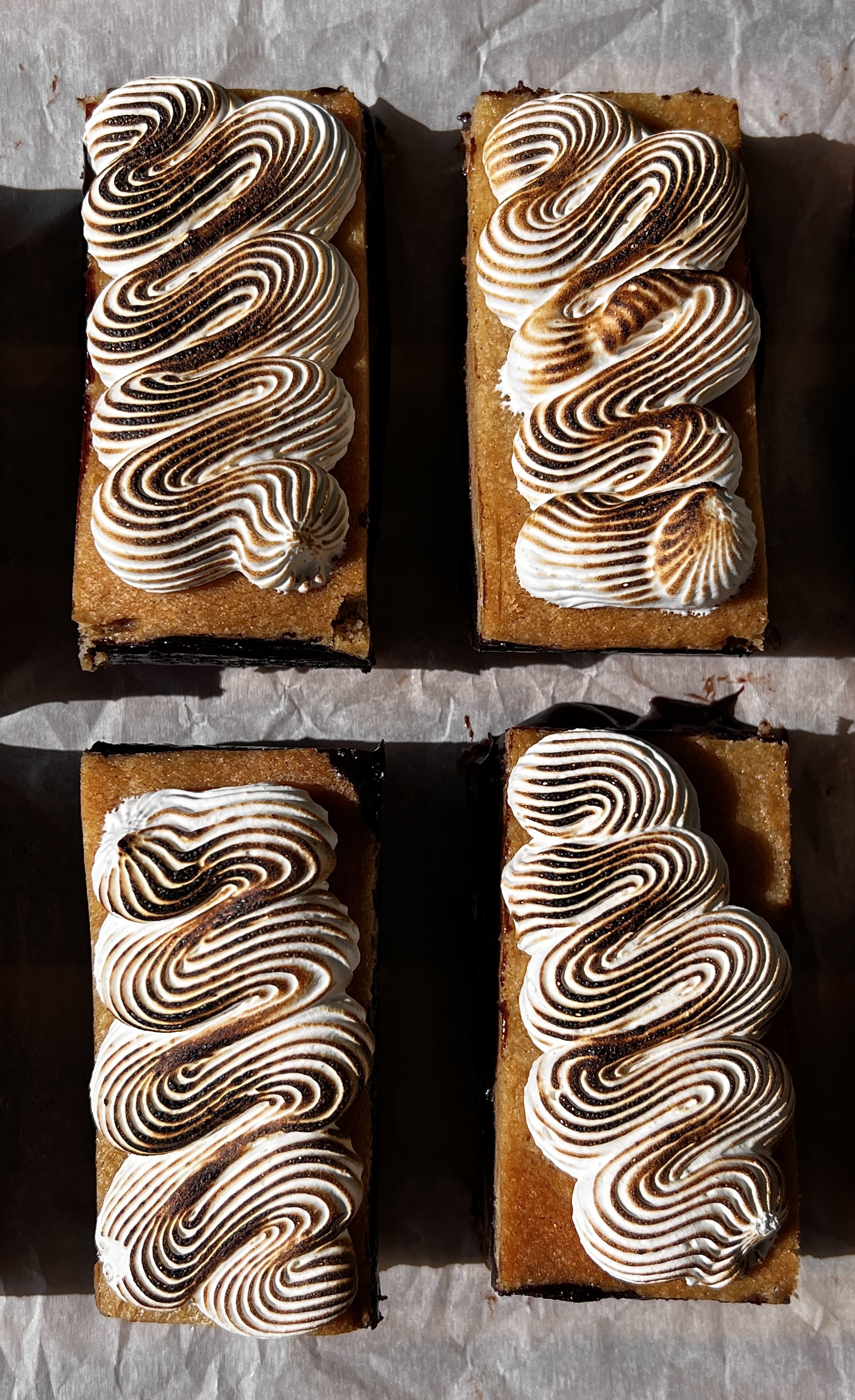 Close-up of a s'mores fudge shortbread bar showing the soft buttery graham cracker shortbread base, rich decadent fudge layer, and perfectly toasted marshmallow creme on top.