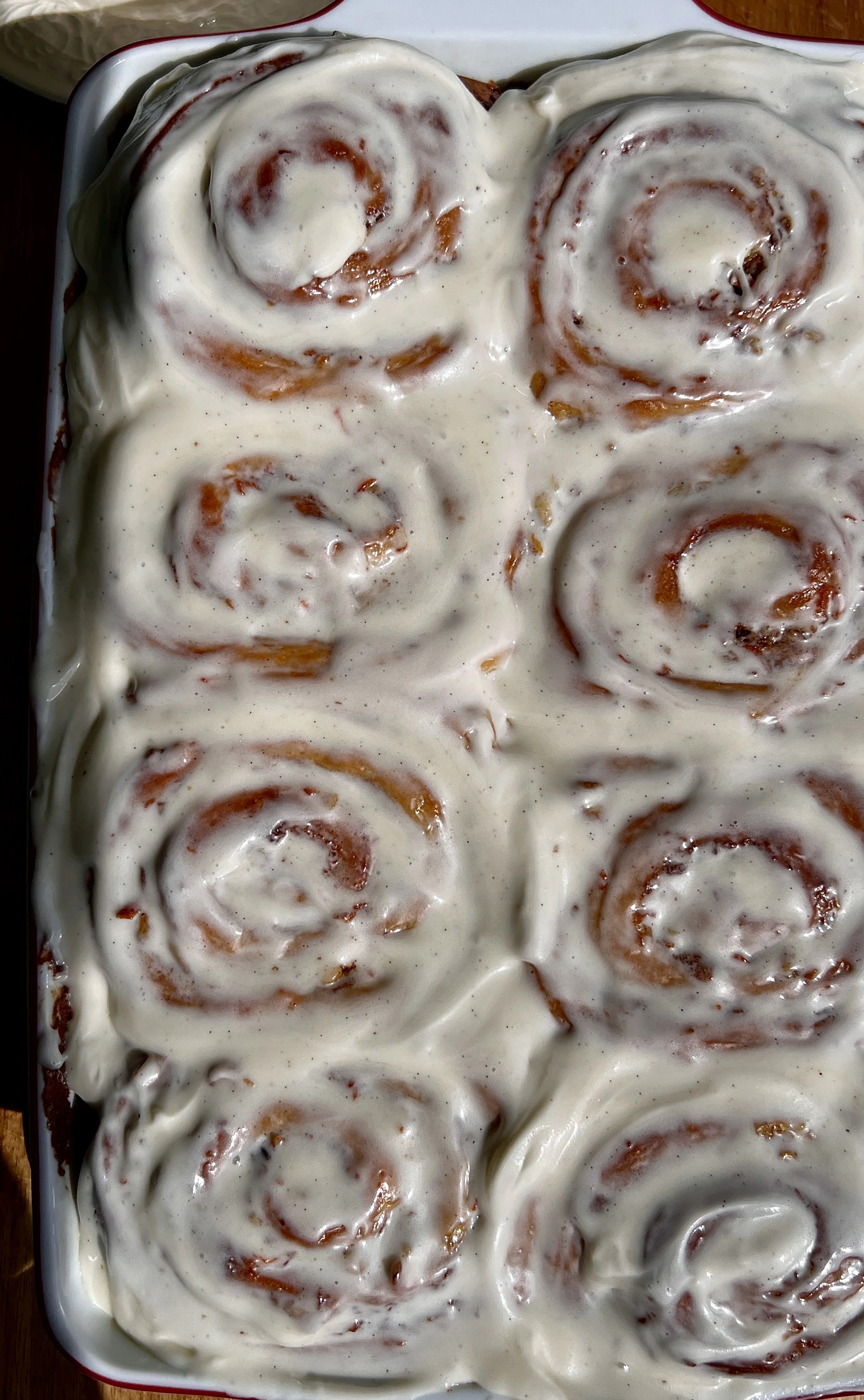 Close-up of carrot cake cinnamon rolls with gooey cinnamon sugar swirls, grated carrots, and chopped walnuts.