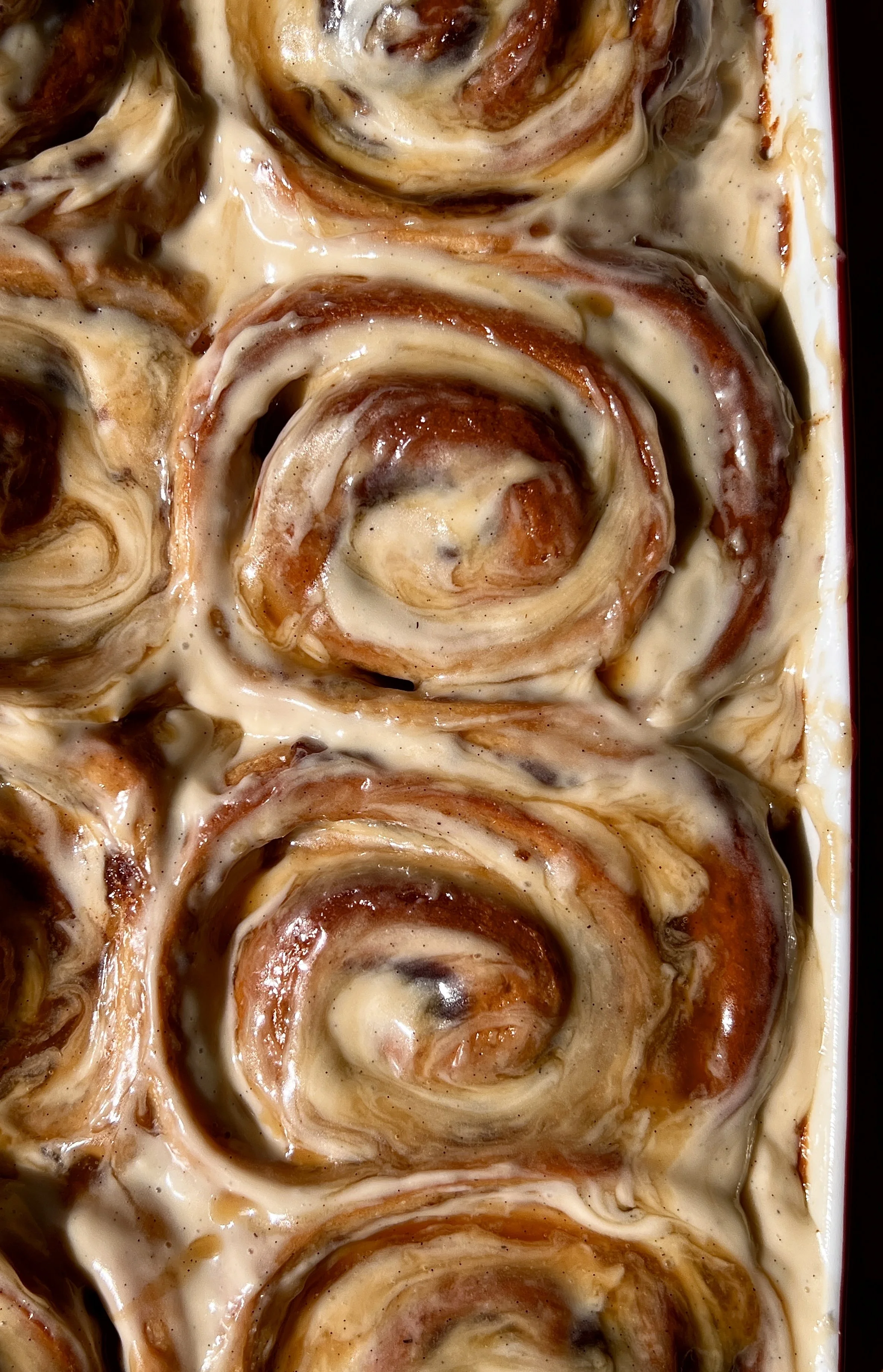 Sticky toffee pudding cinnamon rolls with a maple toffee sauce and brown sugar cream cheese frosting melting into every swirl served warm with a hot cup of coffee.