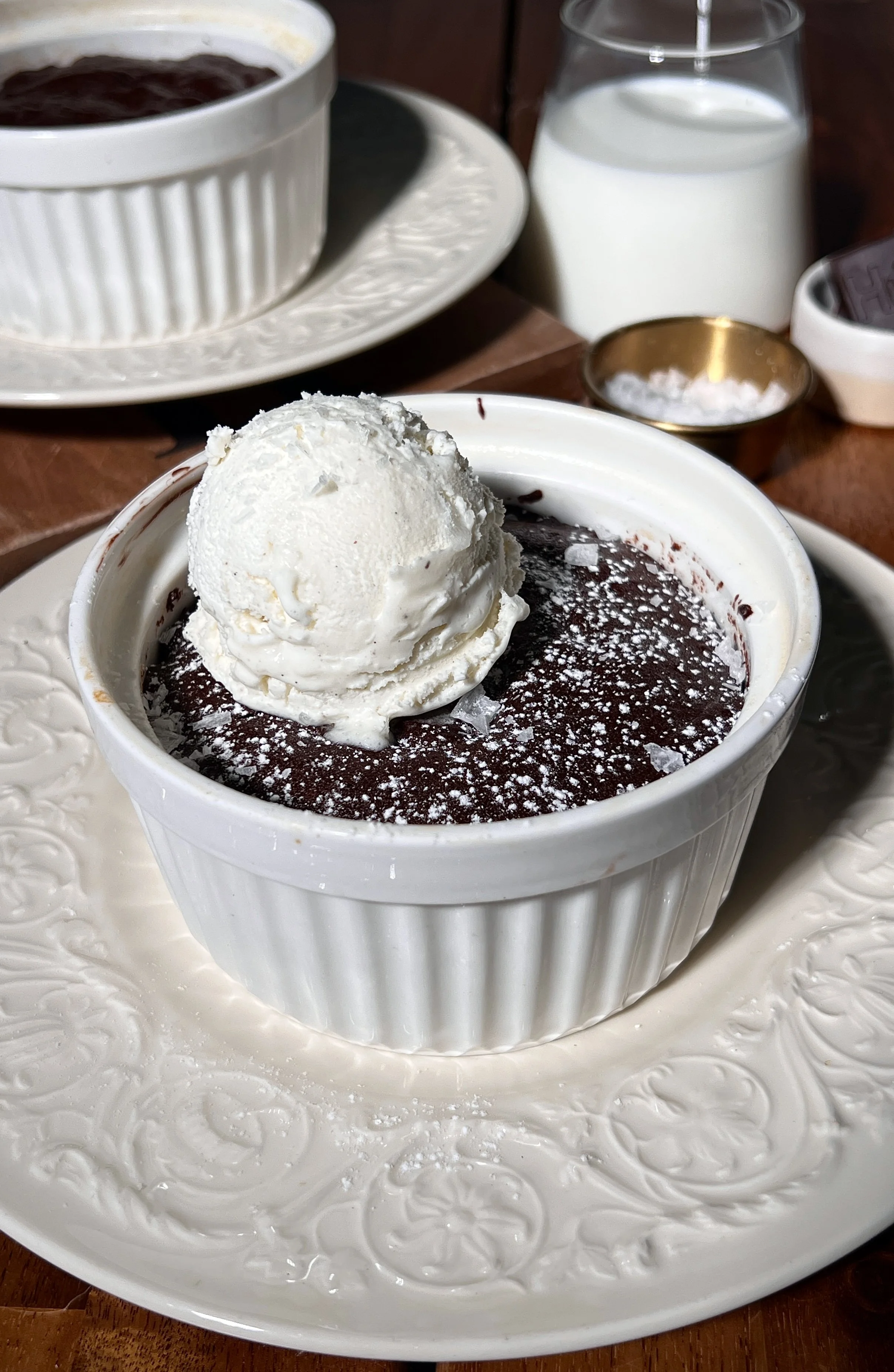 Flourless chocolate cakes for two with a crackly top, powdered sugar, vanilla ice cream, and flaky sea salt.