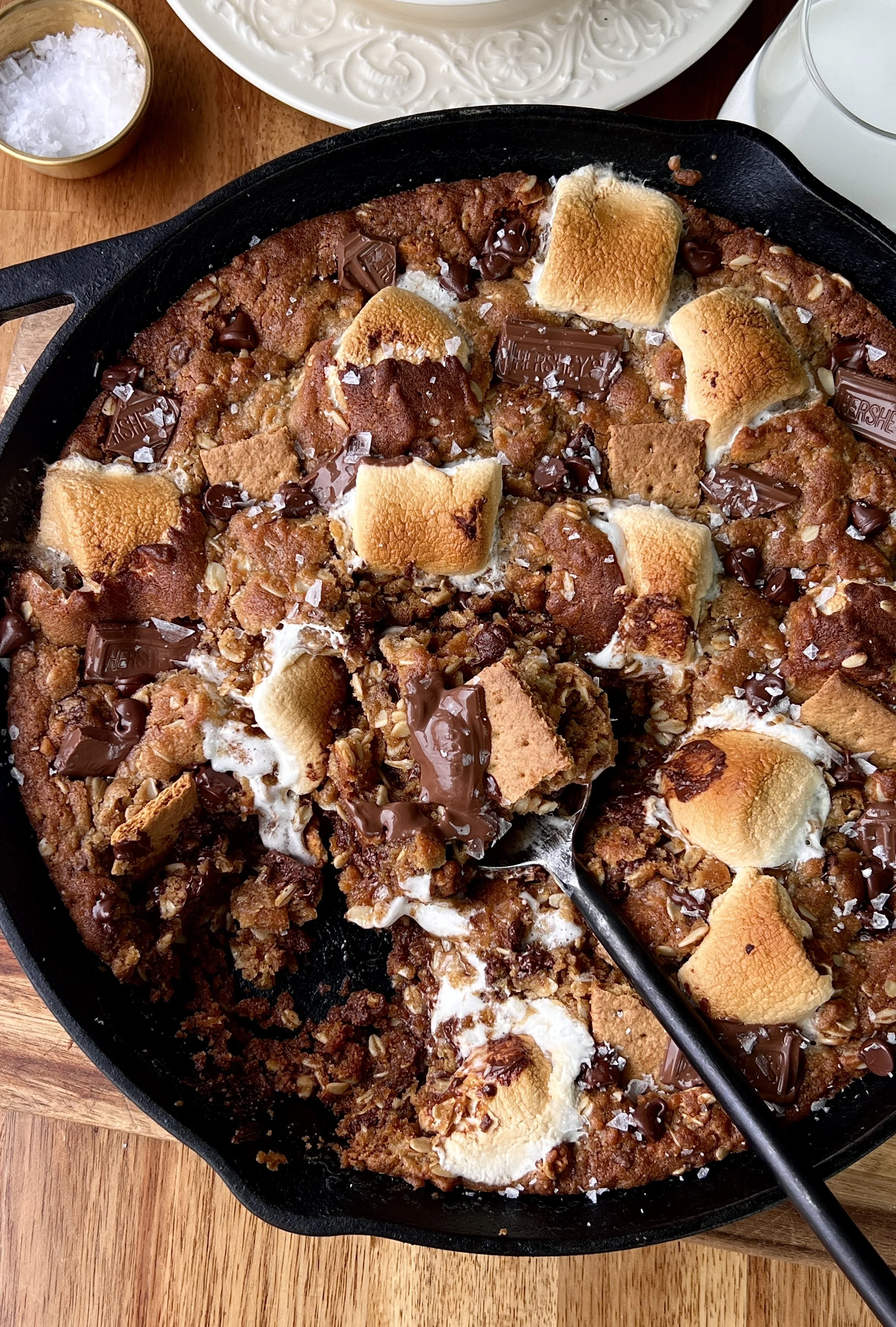 Close-up of a gooey peanut butter s'mores oatmeal cookie skillet with melty chocolate, toasted marshmallows, and crushed graham crackers throughout.