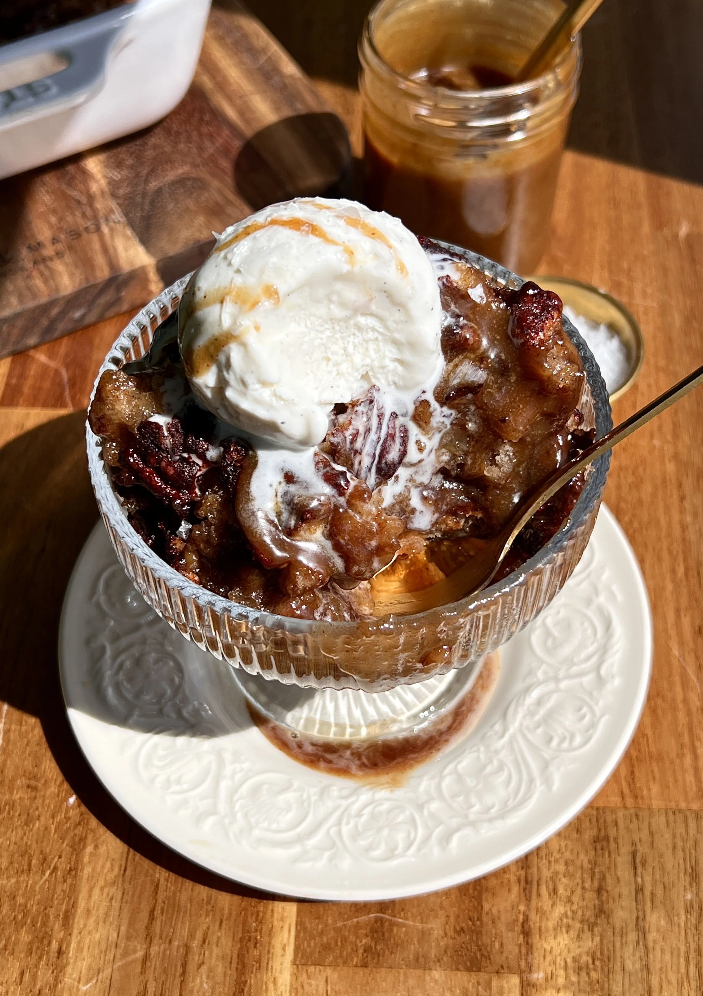 Warm self-saucing banana pudding cake served with vanilla ice cream, toasted pecans, and flaky sea salt.