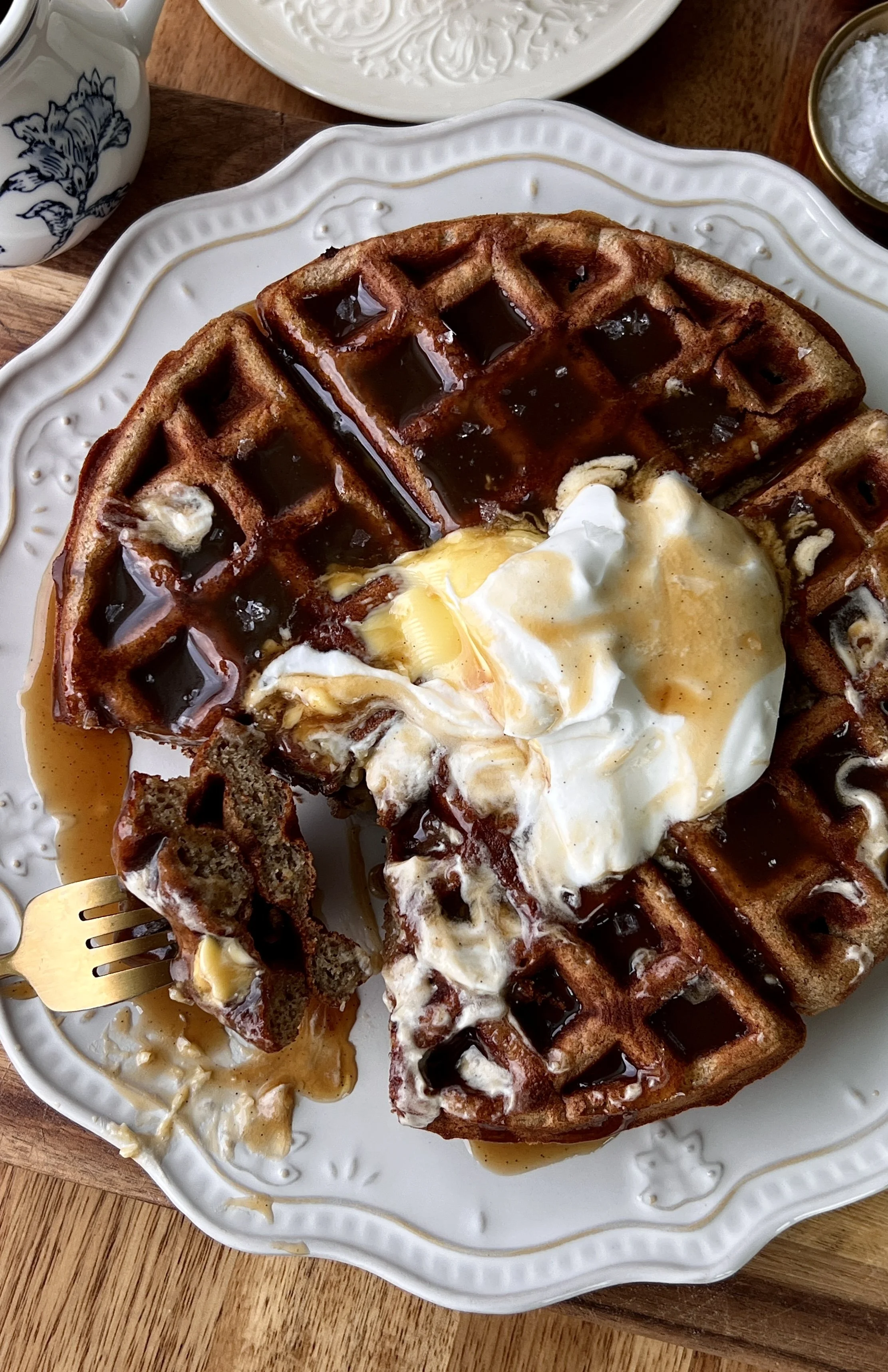 Close-up of a golden and crisp sticky toffee waffle with a soft and fluffy interior drizzled with silky maple toffee sauce.