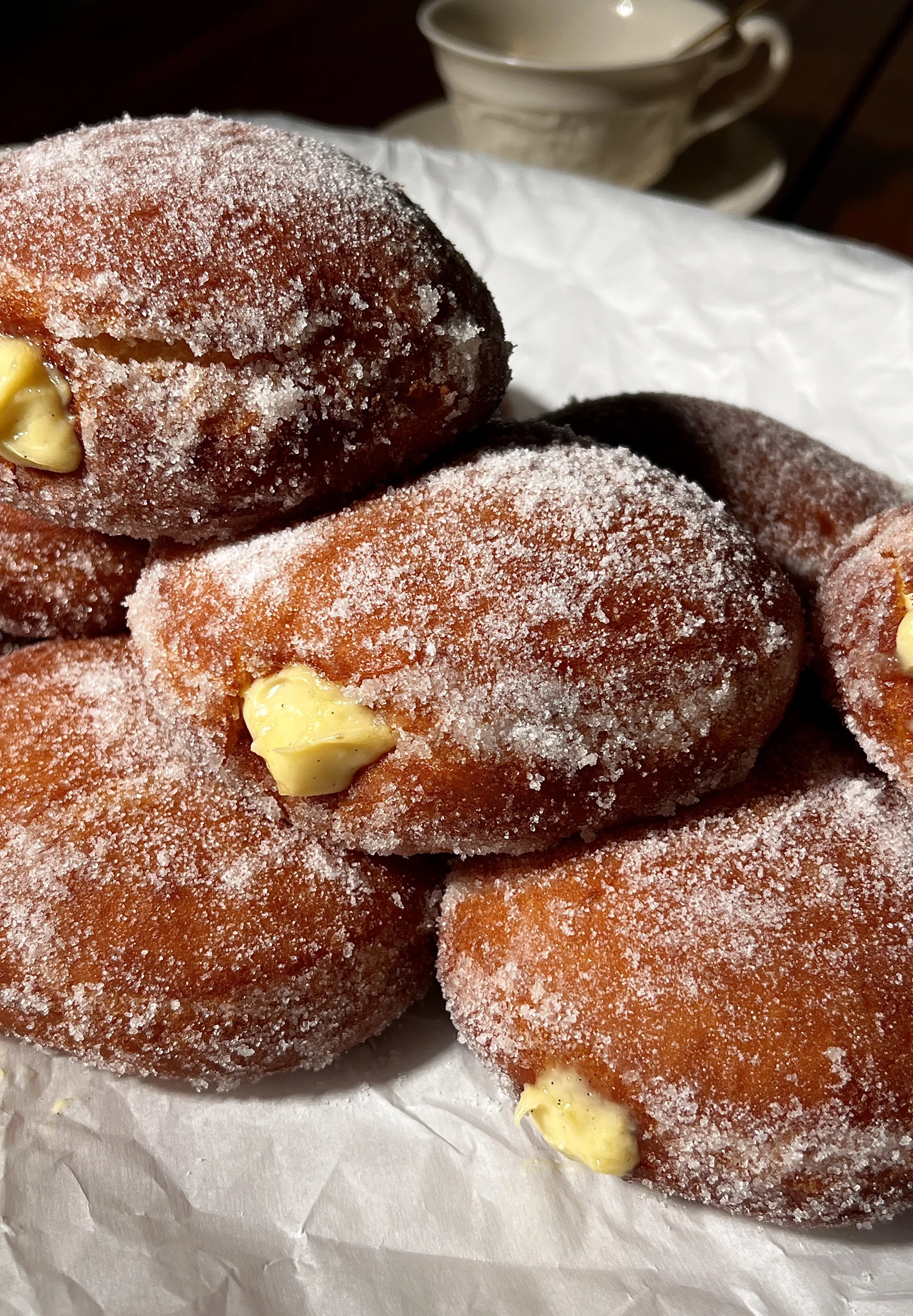 Soft and fluffy vanilla bean coconut cream bomboloni with a golden exterior and creamy custard filling.