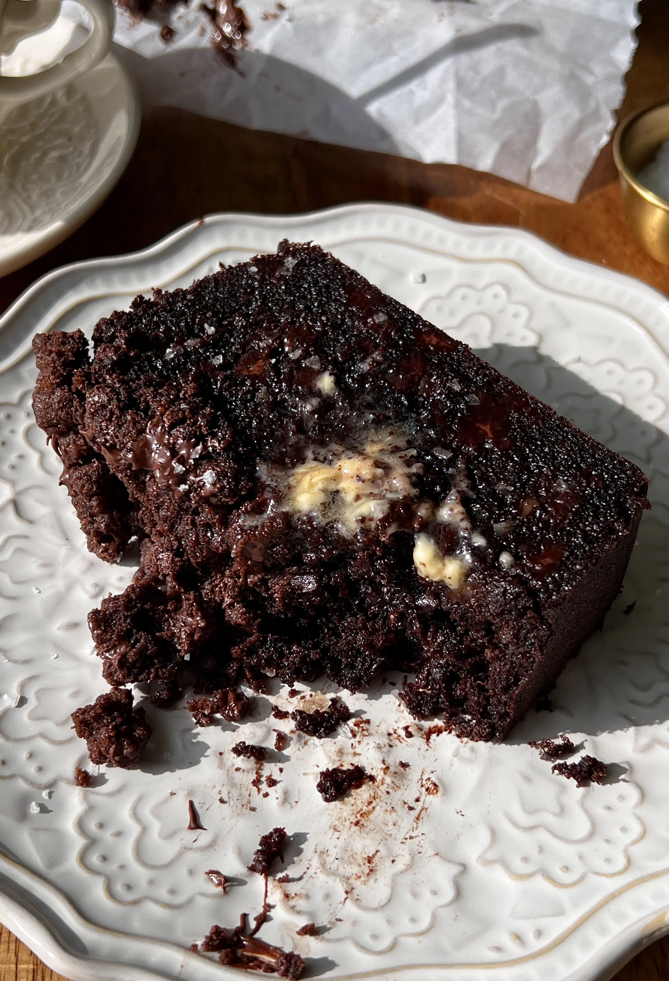 Soft and fluffy double chocolate crumb banana bread with brown butter, melty chocolate chips throughout, and a chocolate chip chocolate crumb topping served warm with a pat of butter and a sprinkle of flaky sea salt.