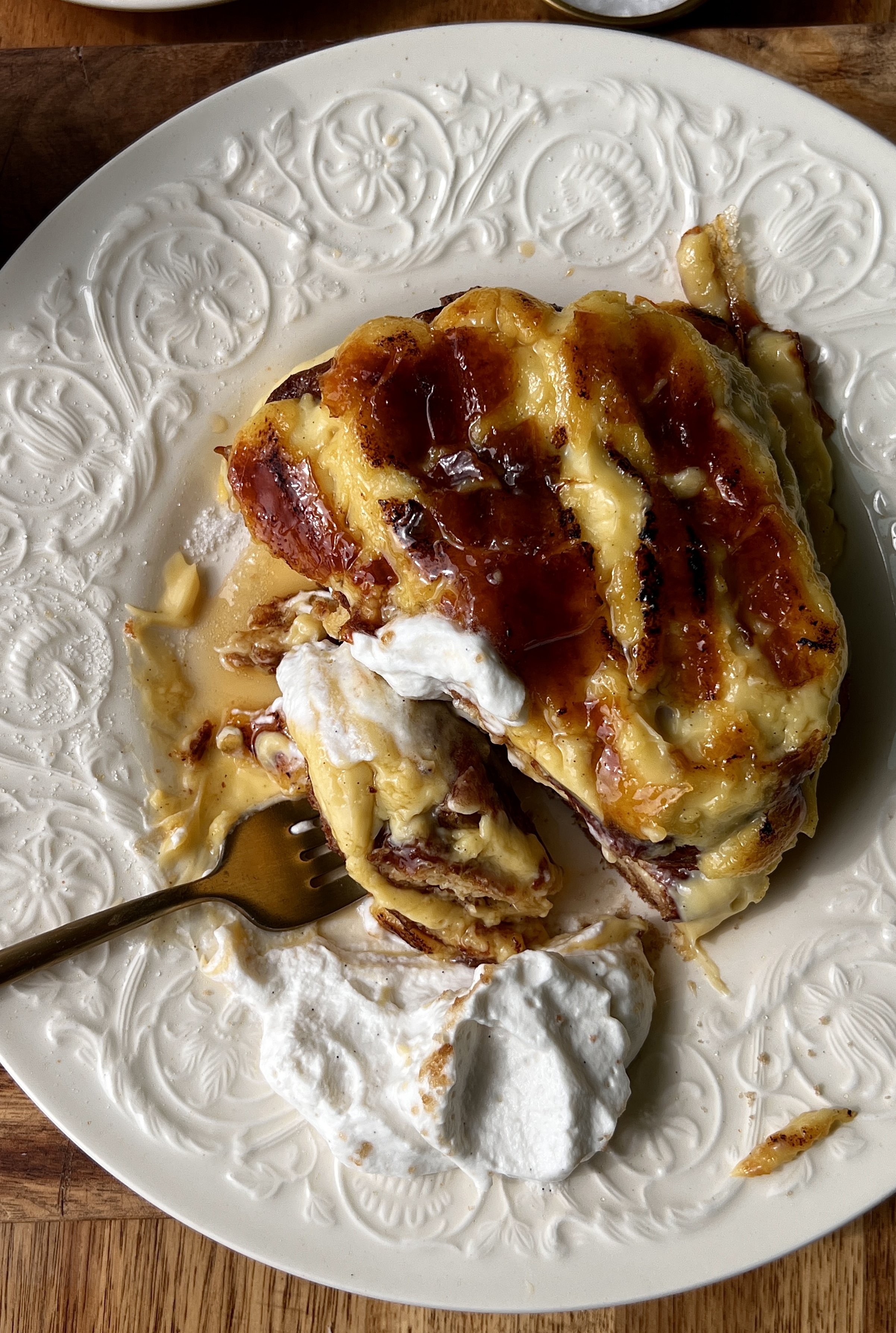 Soft and buttery crème brûlée croissant french toast pan-fried until perfectly golden with a thick vanilla bean custard and crisp caramelized sugar topping served with maple syrup, whipped cream, and a hot cup of coffee.