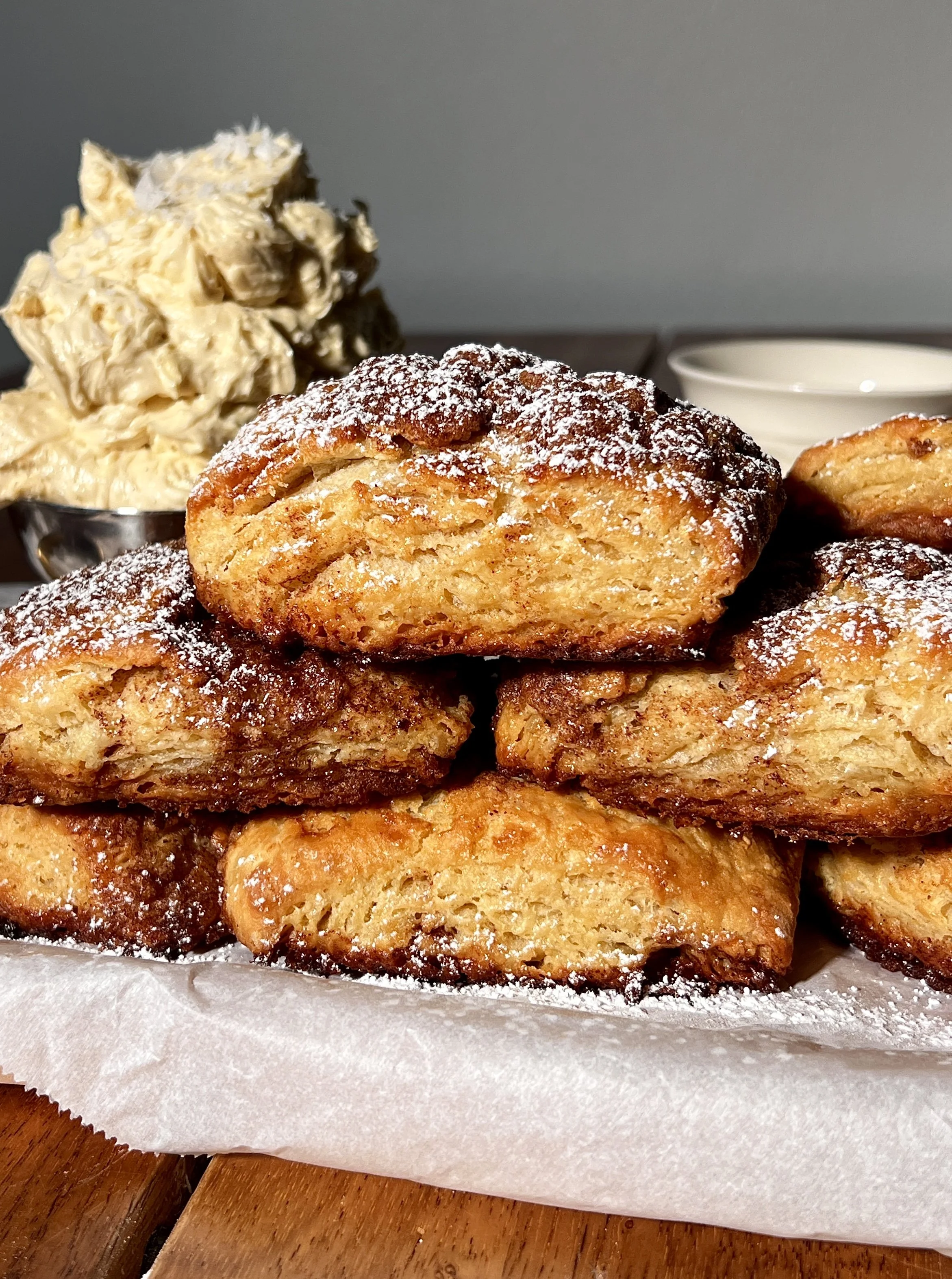 French toast biscuits with a golden flaky exterior, cinnamon sugar swirls, and whipped salted maple butter.