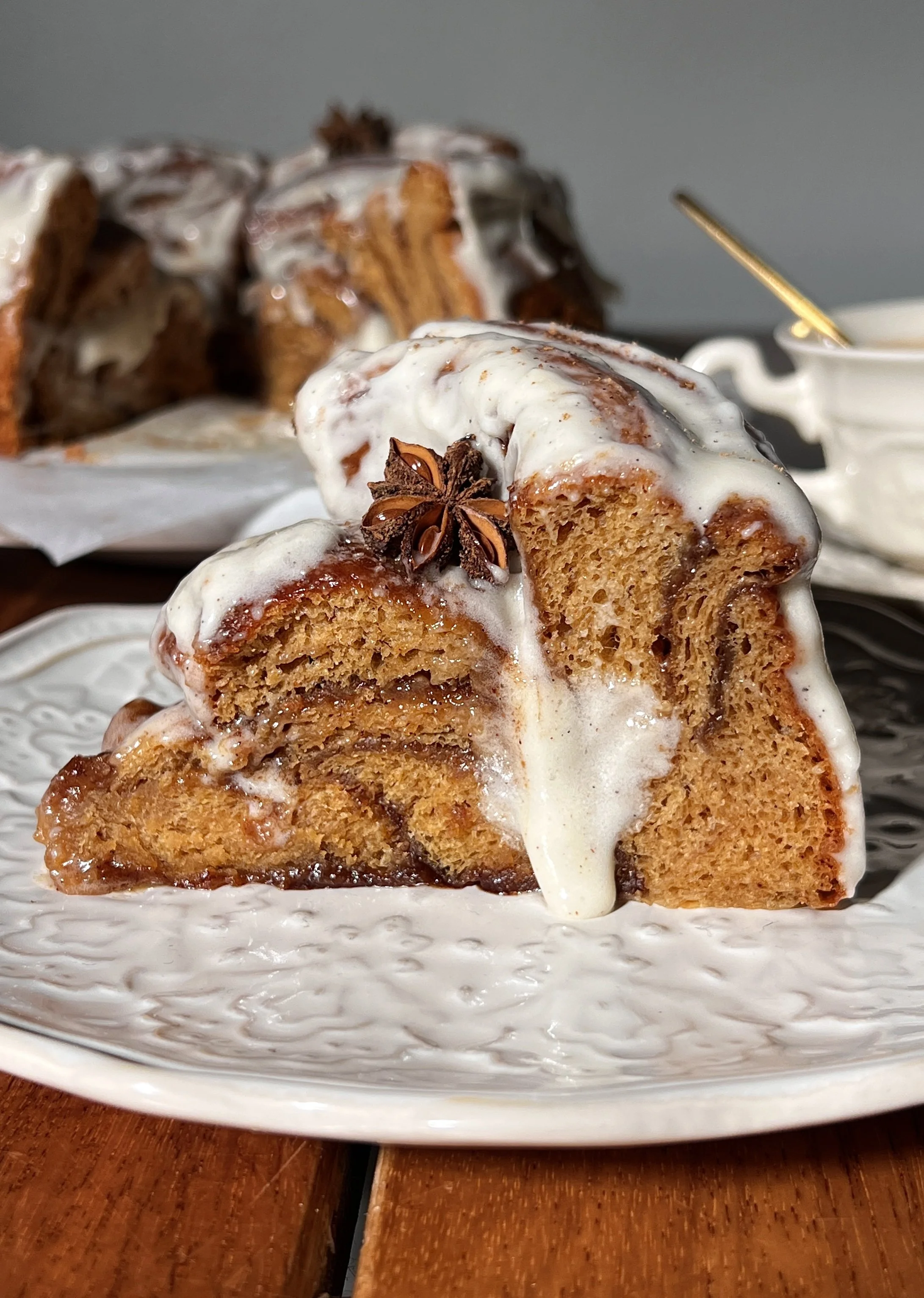 Close-up of a giant gingerbread cinnamon roll showing its soft, gooey center and cream cheese frosting.