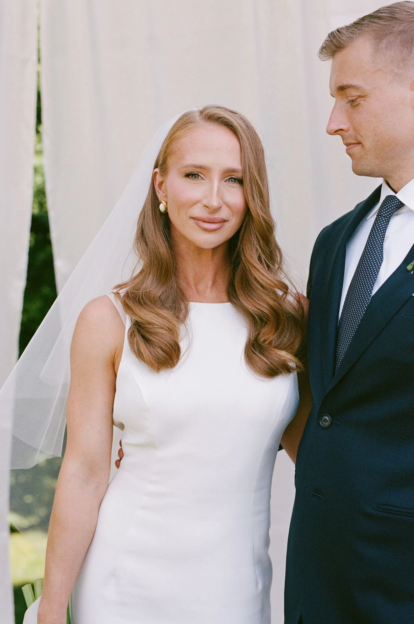 Bride with a natural custom spray tan by Schulz Beauty posing with the groom on their wedding day in Toronto