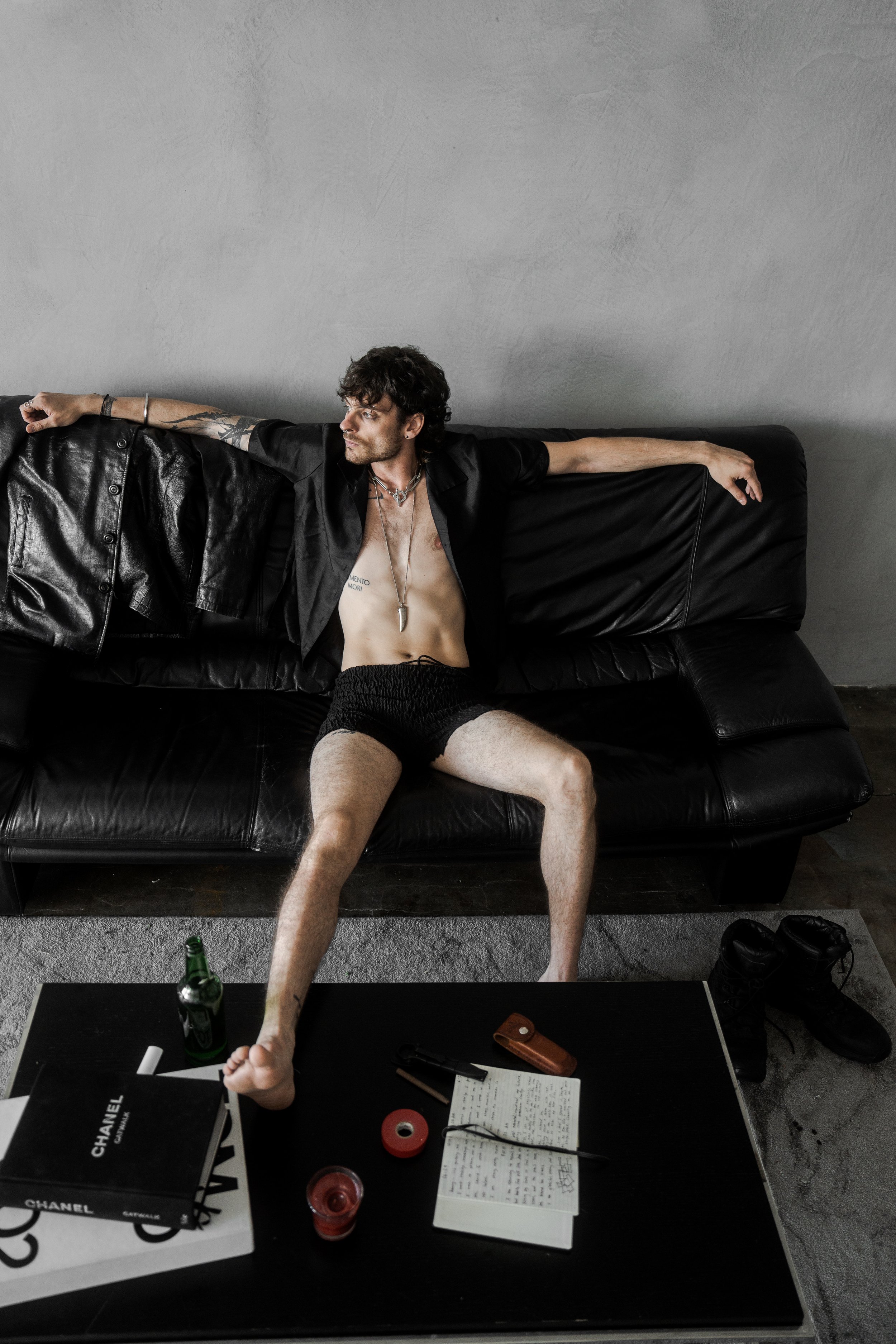 XINIX sitting on couch in low light wearing open shirt dark cinematic moody aesthetic