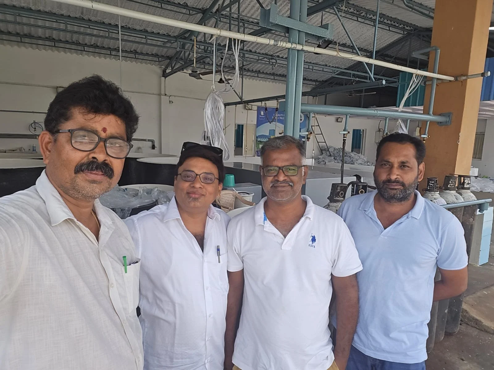 Fem menn står sammen og tar et gruppebilde innendørs.